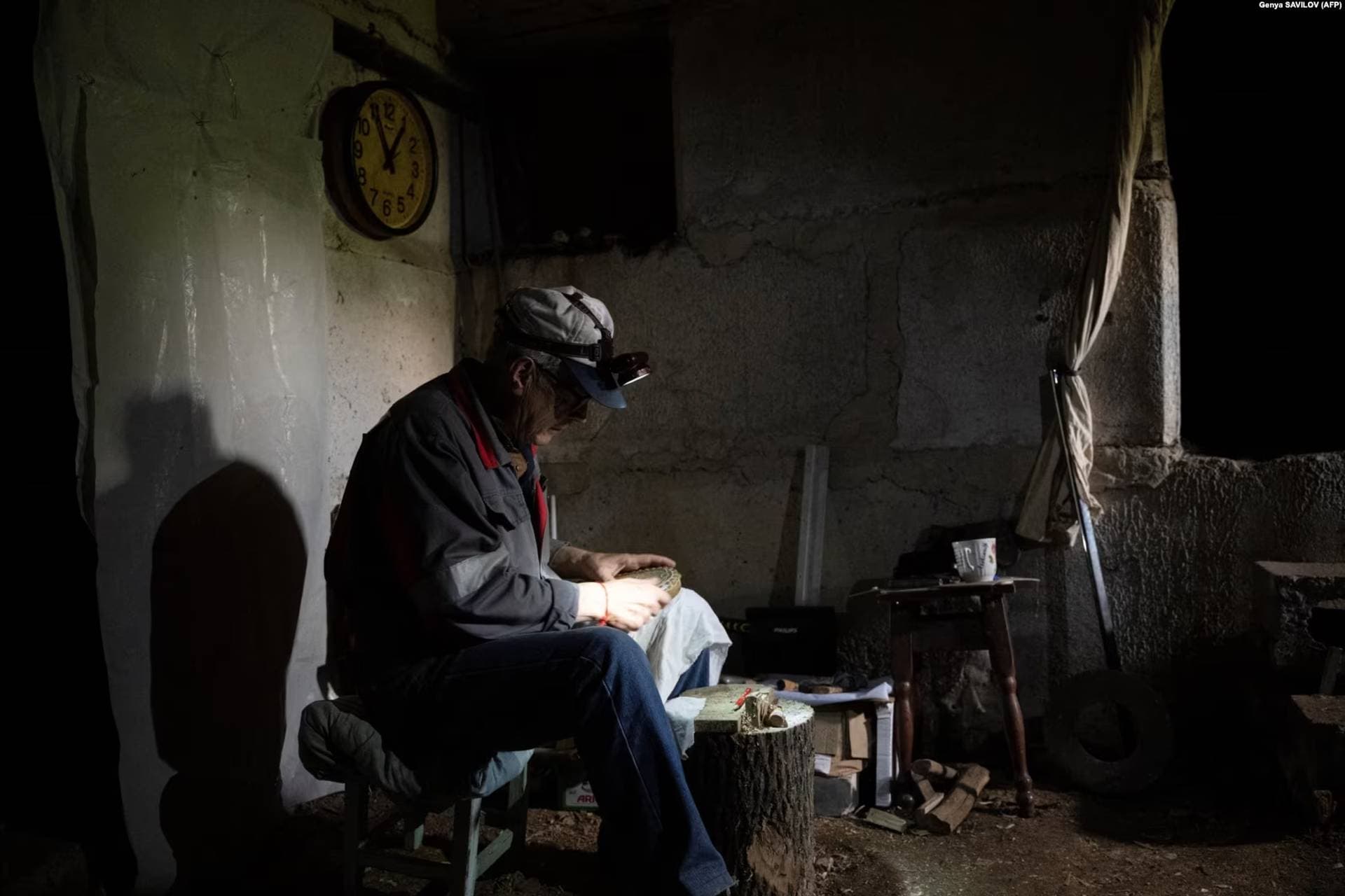 Vitaliy Zemin sits in the cellar, where he lives with his wife