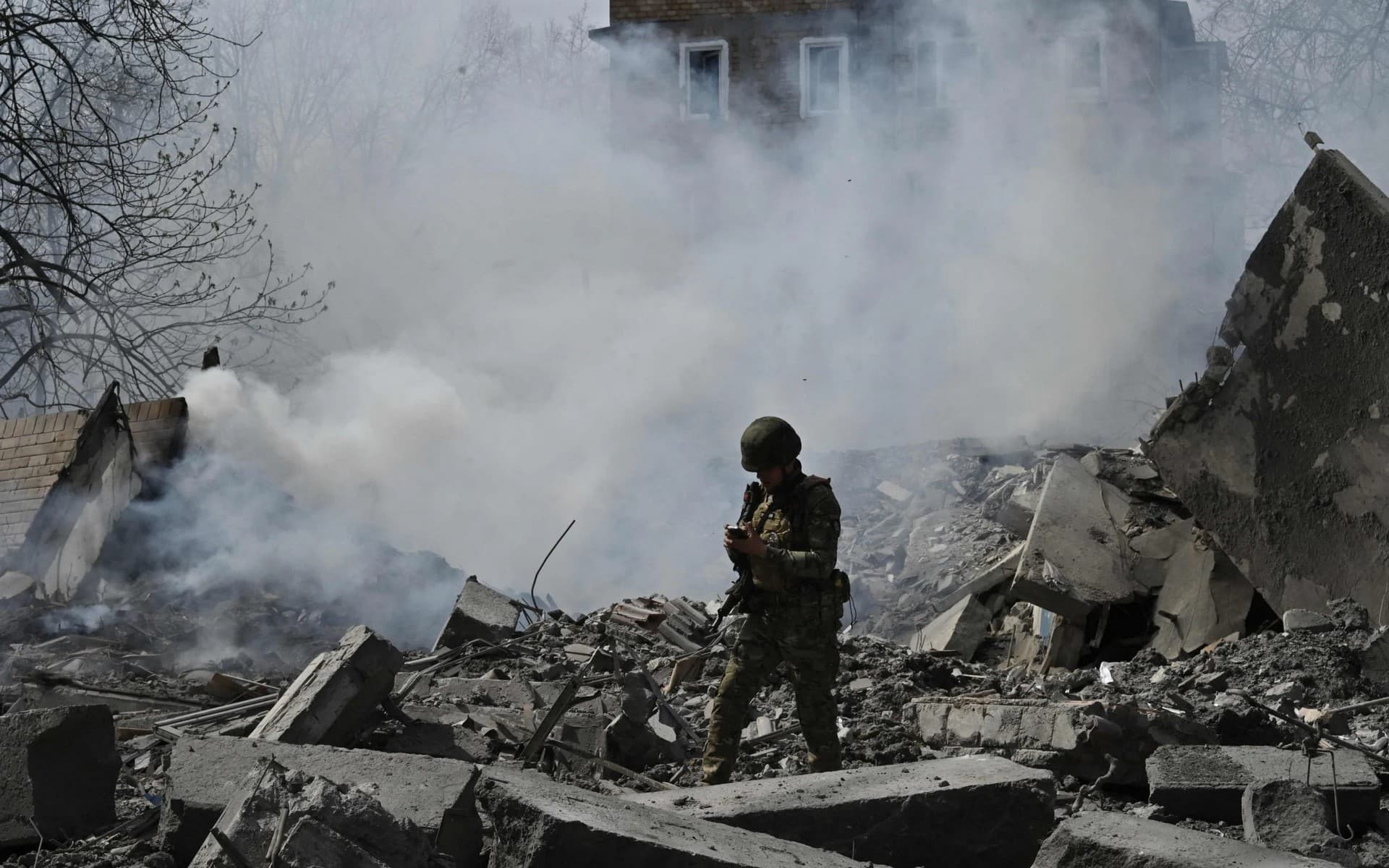 A member of the Ukrainian White Angels Special Police Team walks amongst the debris of a multi-storey residential building in Avdiivka