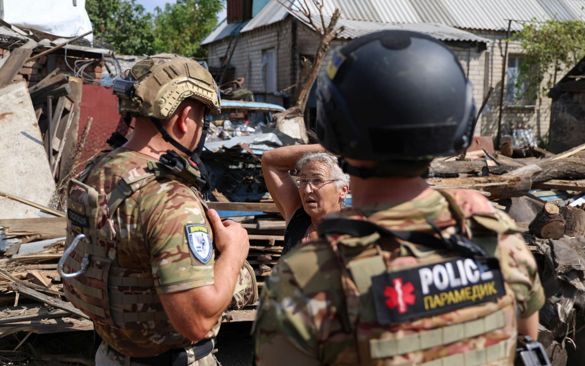 A local woman reacts as she tell the police about how her house was recently shelled in Avdiivka settlement