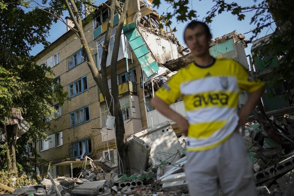 A local resident stands next to a residential building heavily damaged in a Russian bombing in Bakhmut