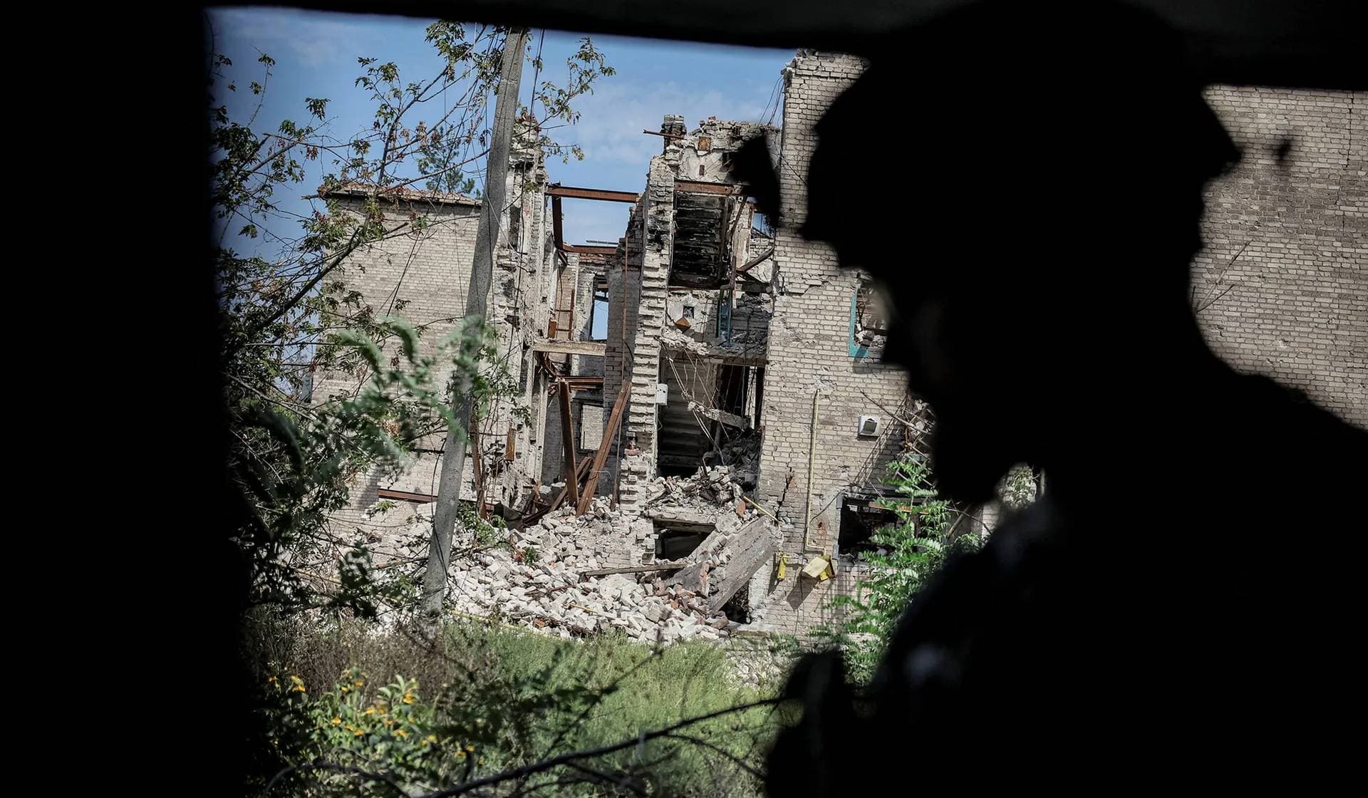 A Ukrainian serviceman near residential buildings heavily damaged during a Russian military attack in the frontline town of Chasiv Yar
