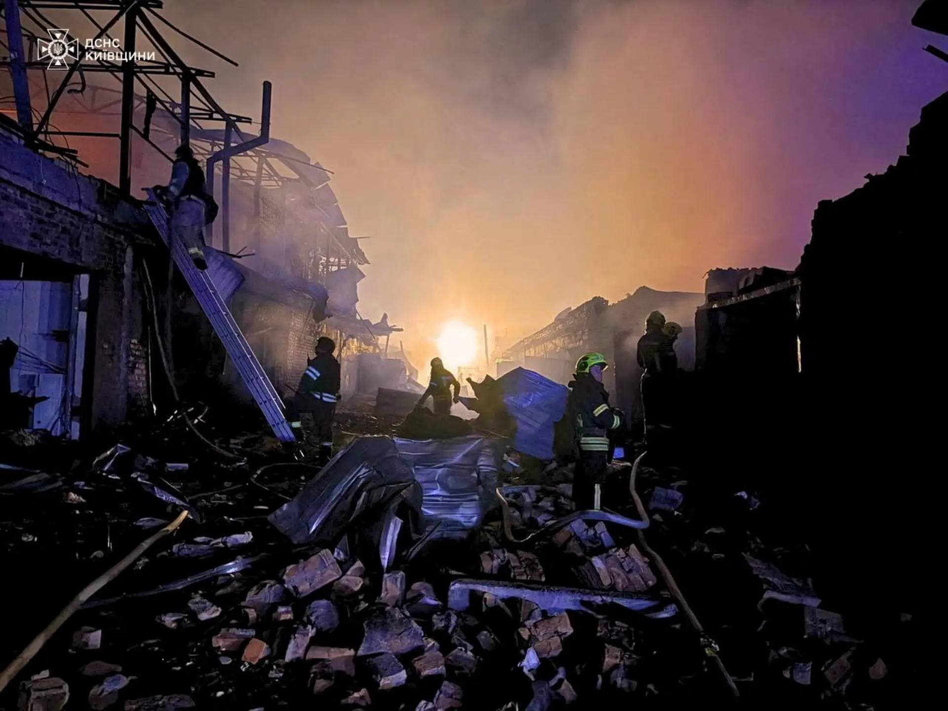 Firefighters work at the site of car garages hit by a Russian drone strike in Bila Tserkva
