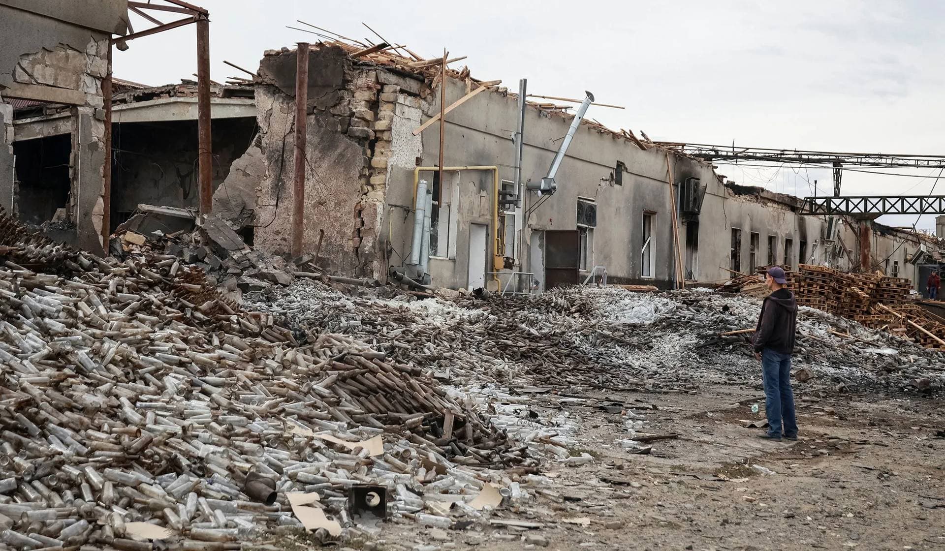 An employee stands near a distillery destroyed by a Russian drone strike on Sunday in the town of Bilhorod-Dnistrovskyi