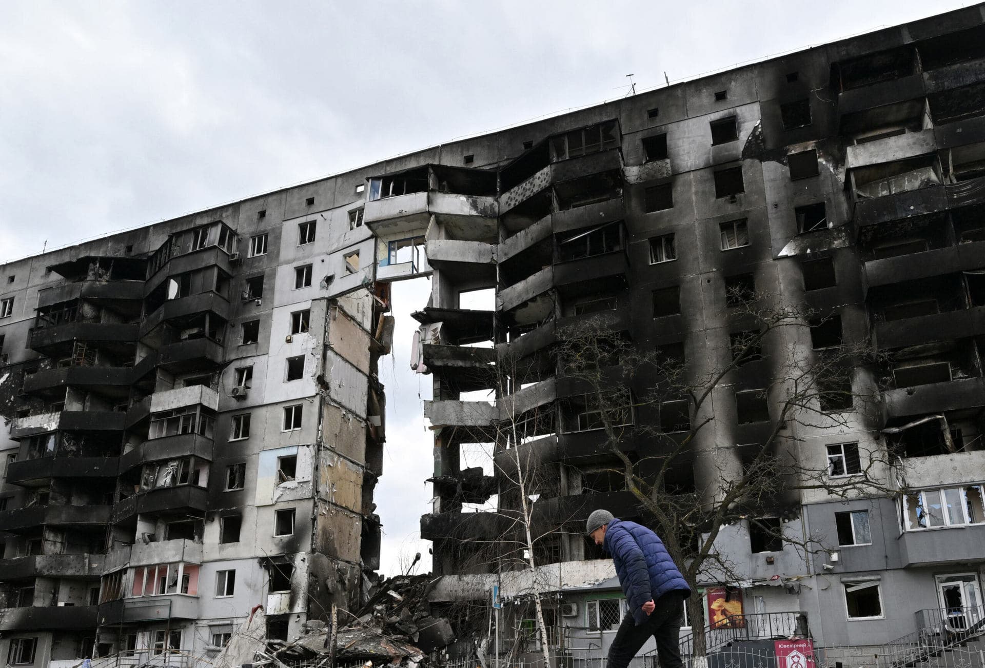 A man walks past destroyed buildings in the town of Borodianka