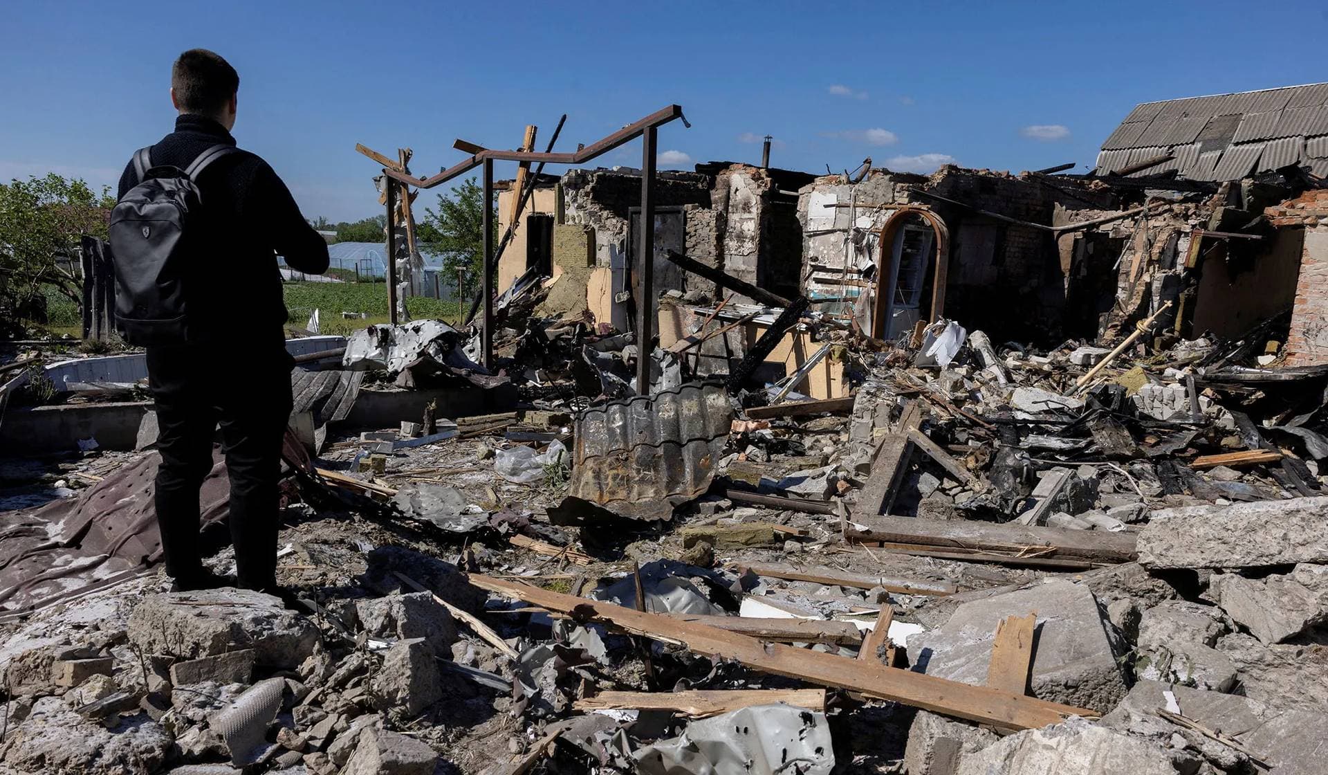 A man surveys the damage of a house that was hit during a Russian missile strike in Krasylivka