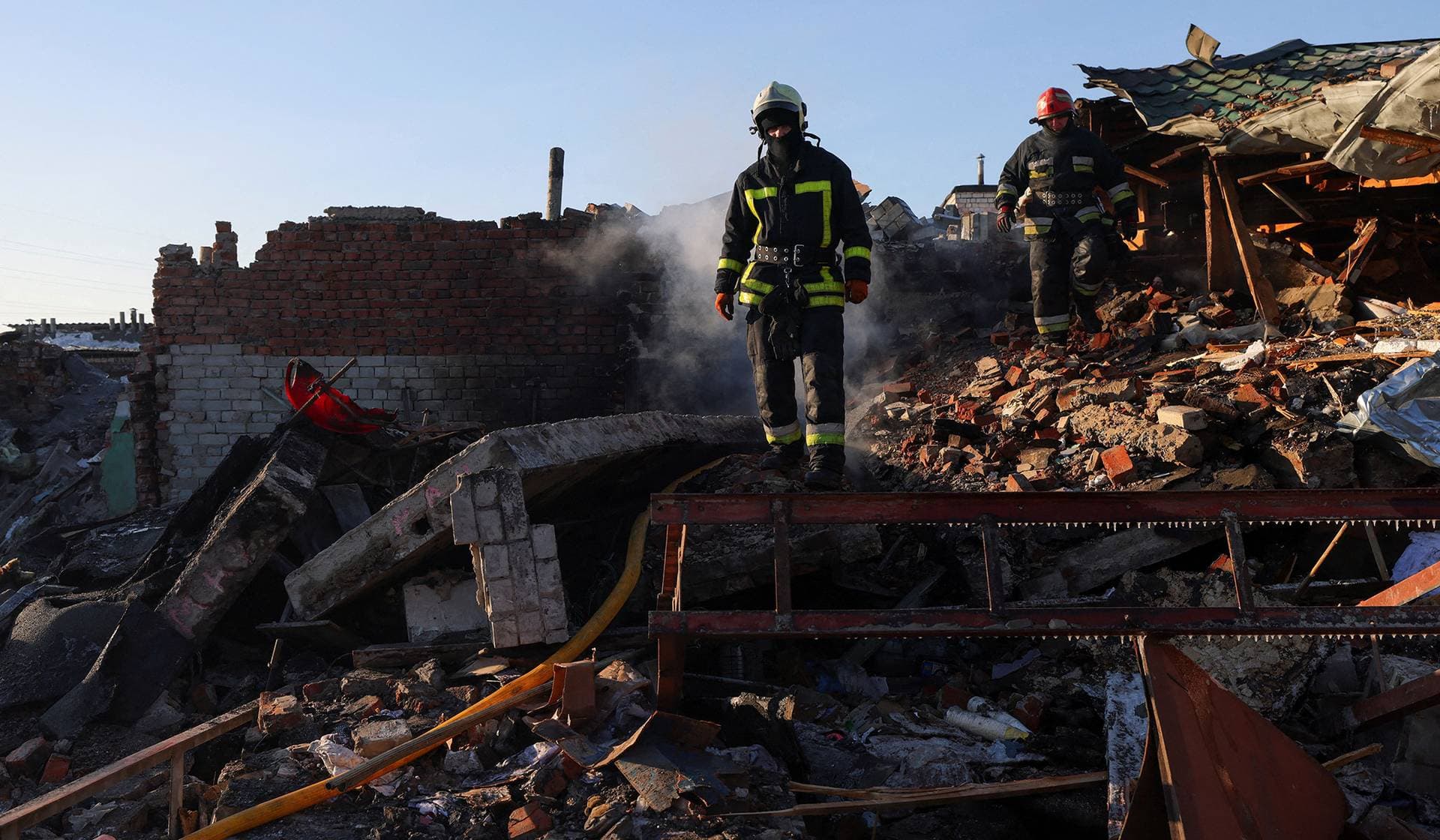 Firefighters work at the site of car garages hit by a Russian missile strike in Chernihiv