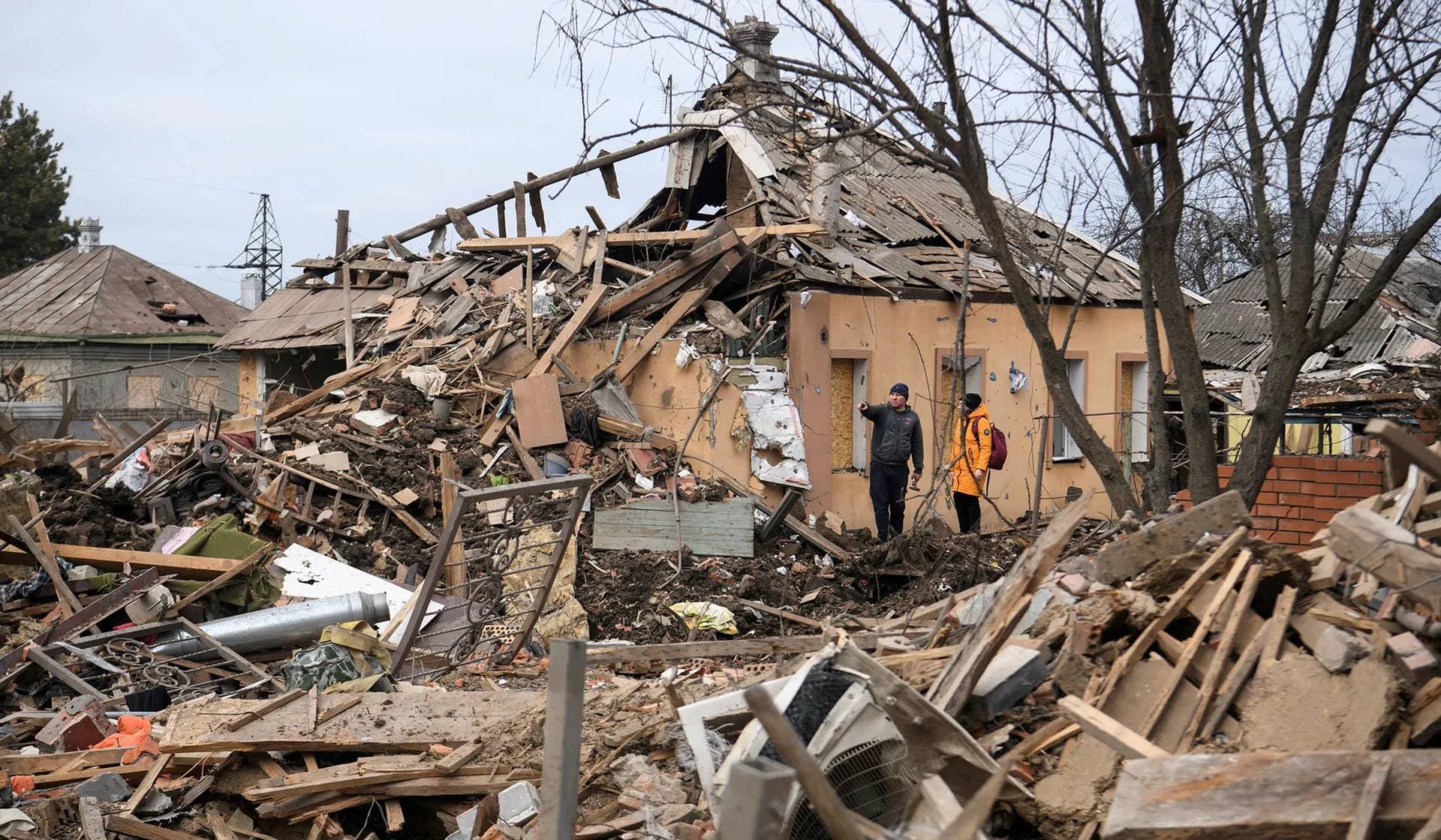 Local residents stand next to a building heavily damaged by a Russian missile strike in Chuhuiv