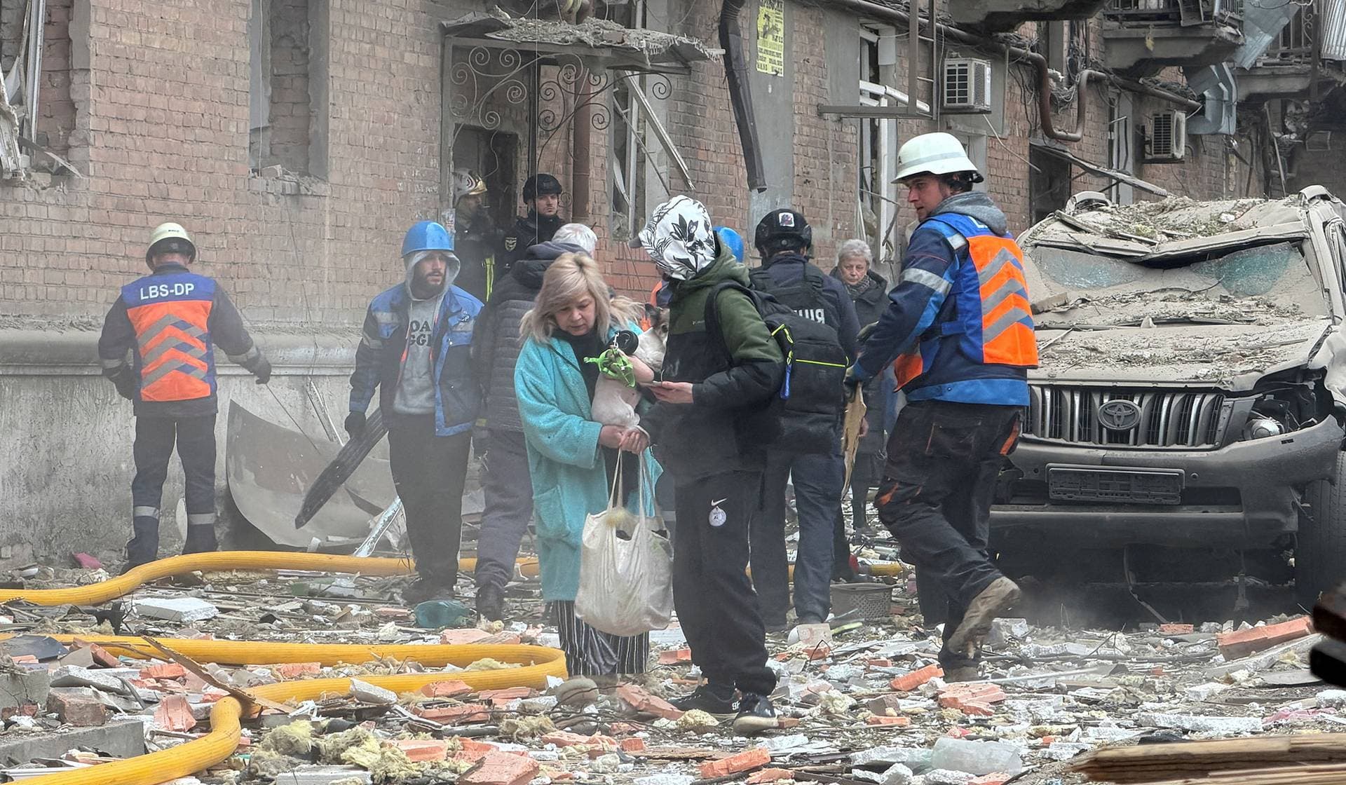 Residents leave the site of an apartment building hit by a Russian drone and missile strike in Dnipro