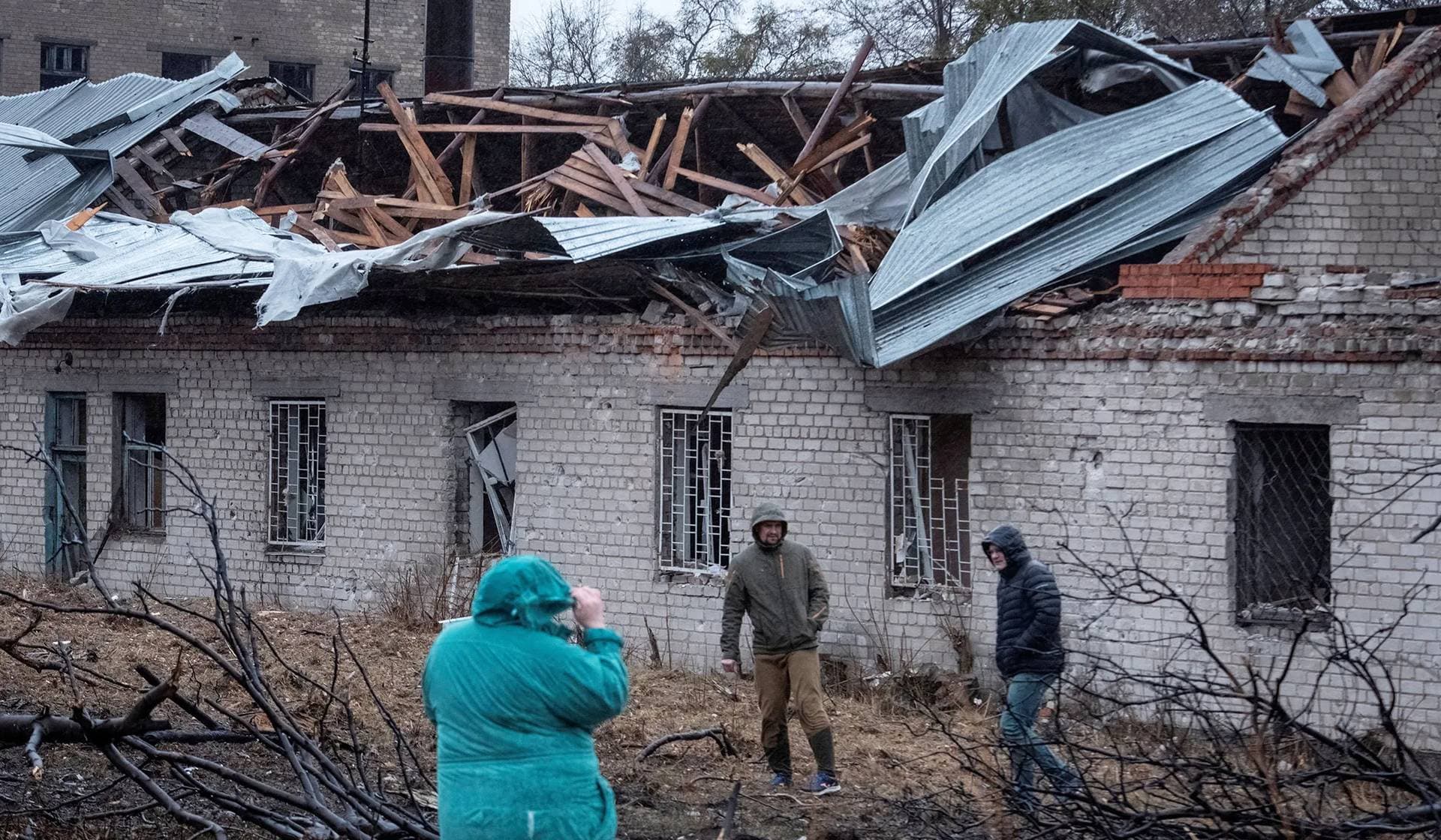 Residents walk at a site of a Russian missile strike in Dnipro