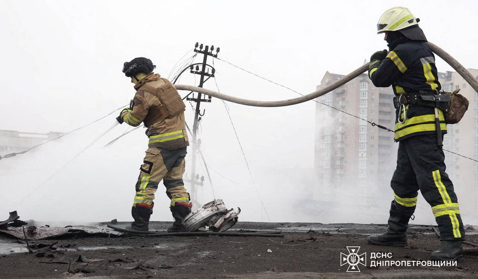Firefighters work at the site of a midday Russian missile strike in Dnipro