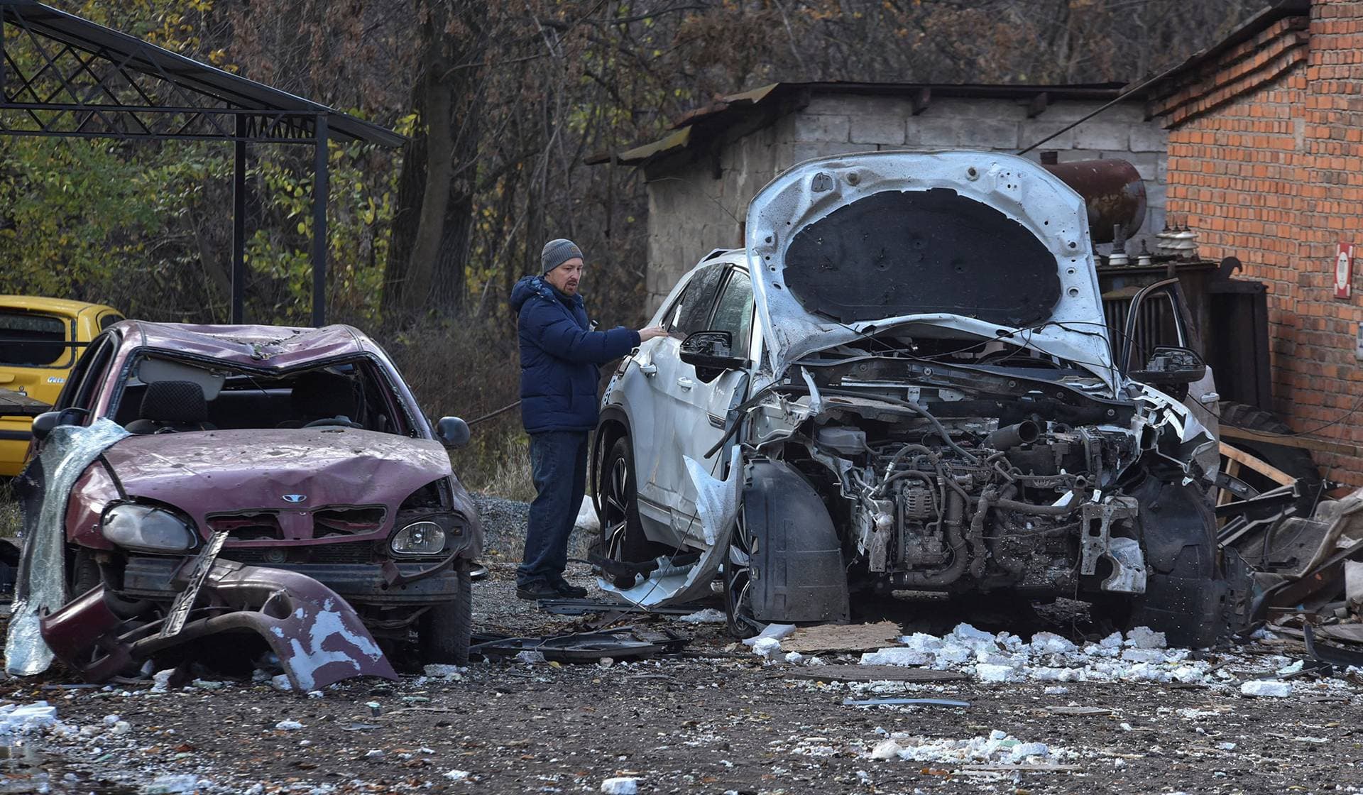 A resident checks a car damaged by a Russian drone strike in Dnipro