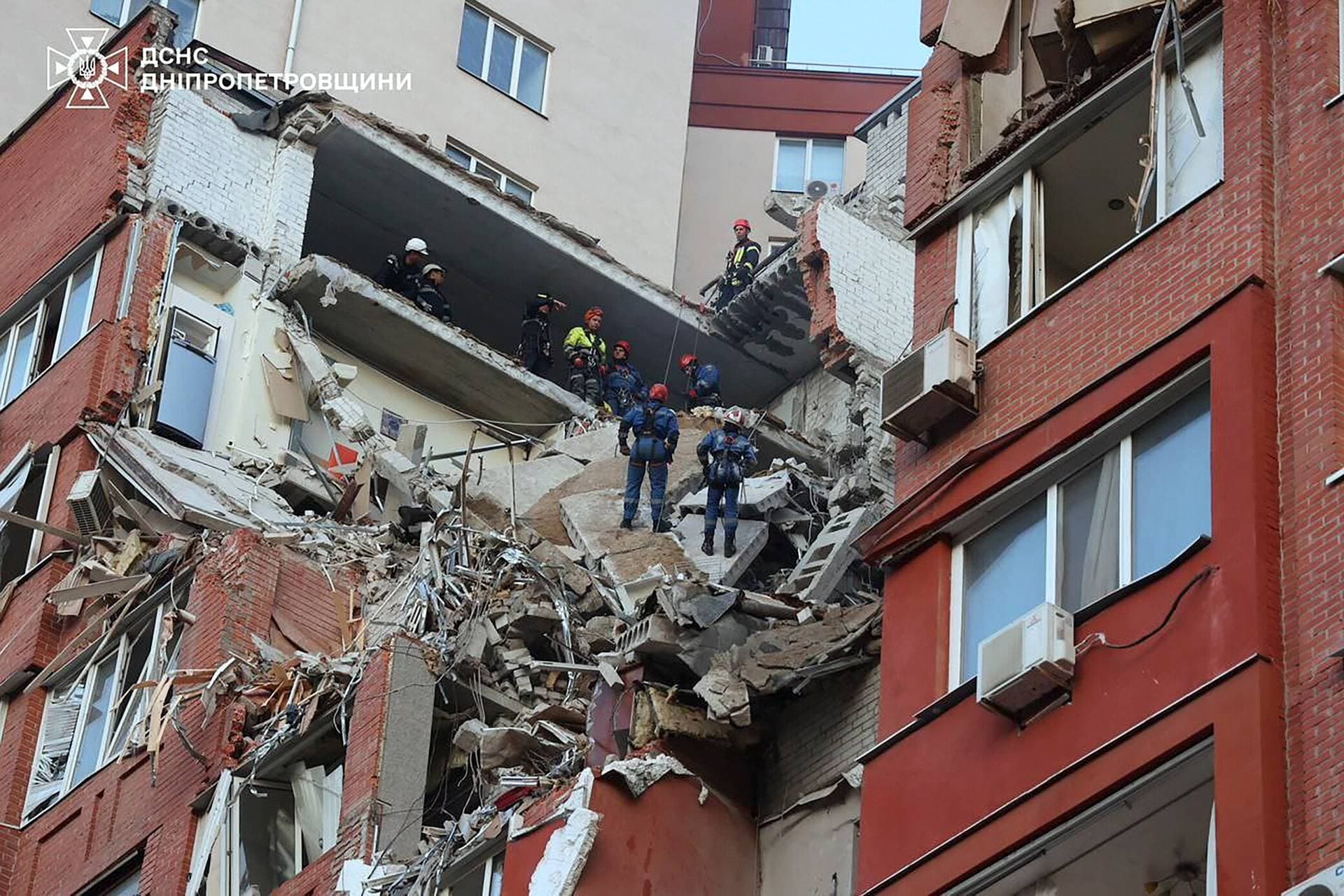 Residents walk at a site of a Russian missile strike in Dnipro