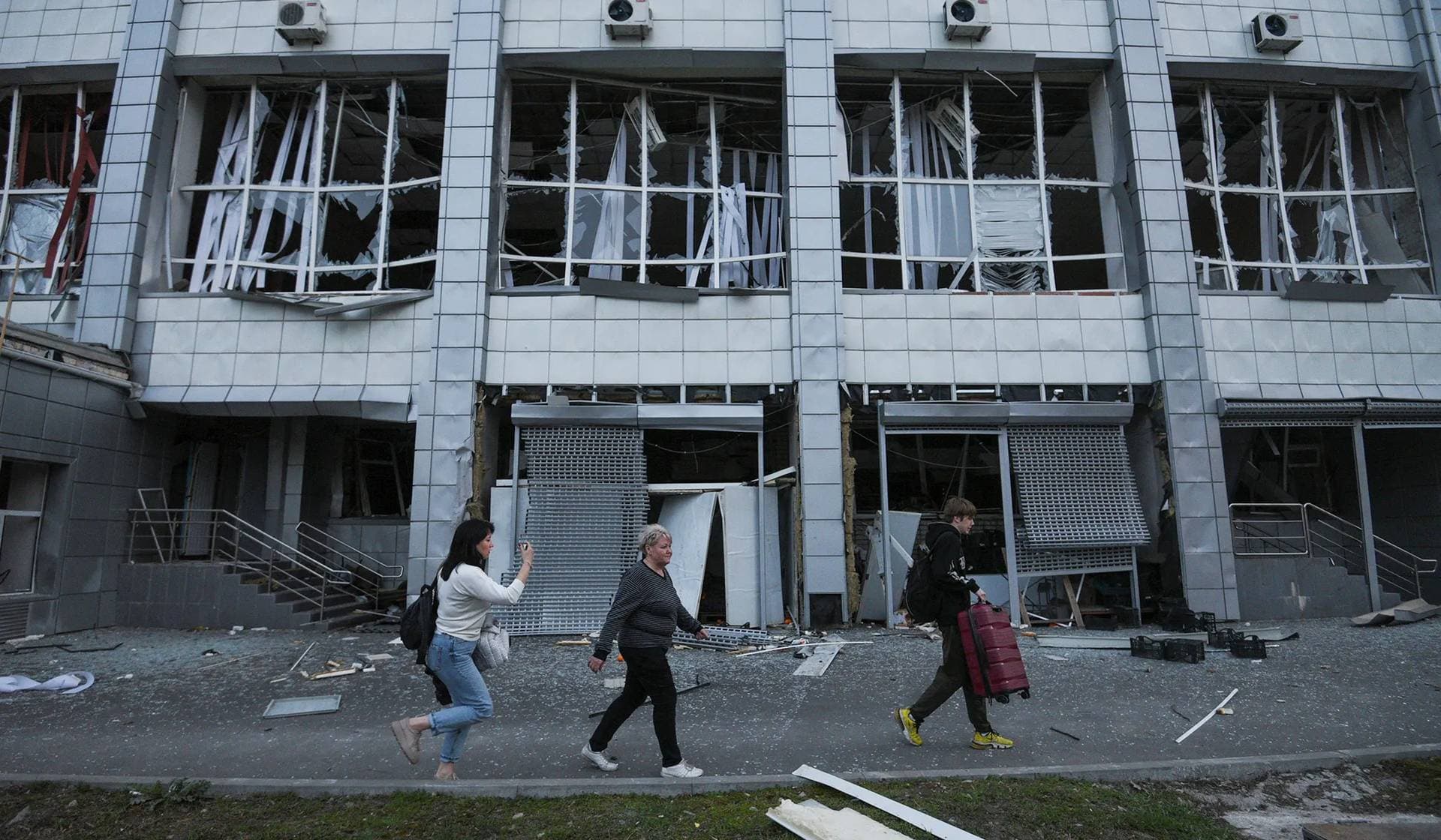 People walk in a front of the building of a sports college damaged during a Russian missile strike in Dnipro