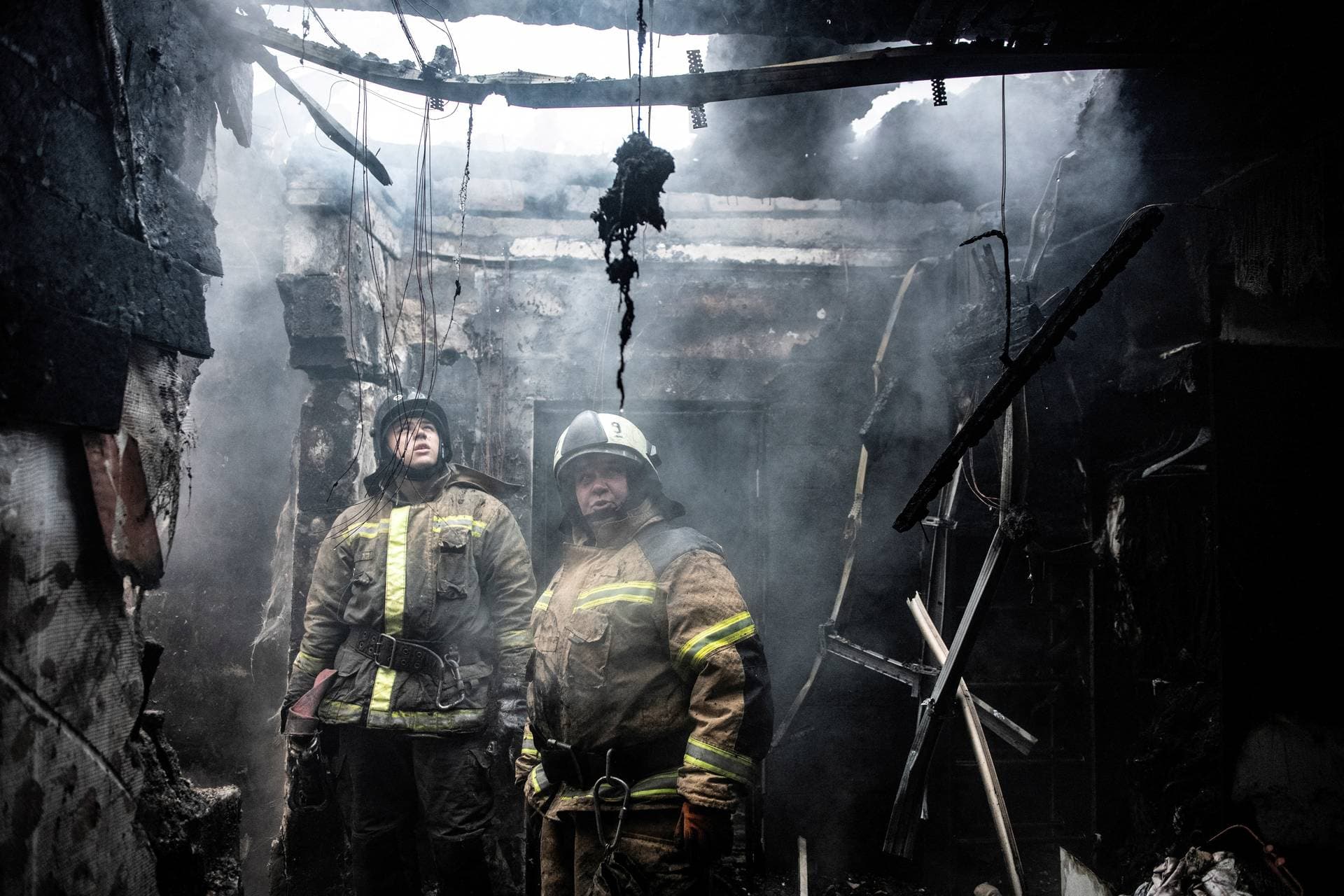 Rescuers work to put out fire in a damaged residential building hit by recent shelling in Donetsk