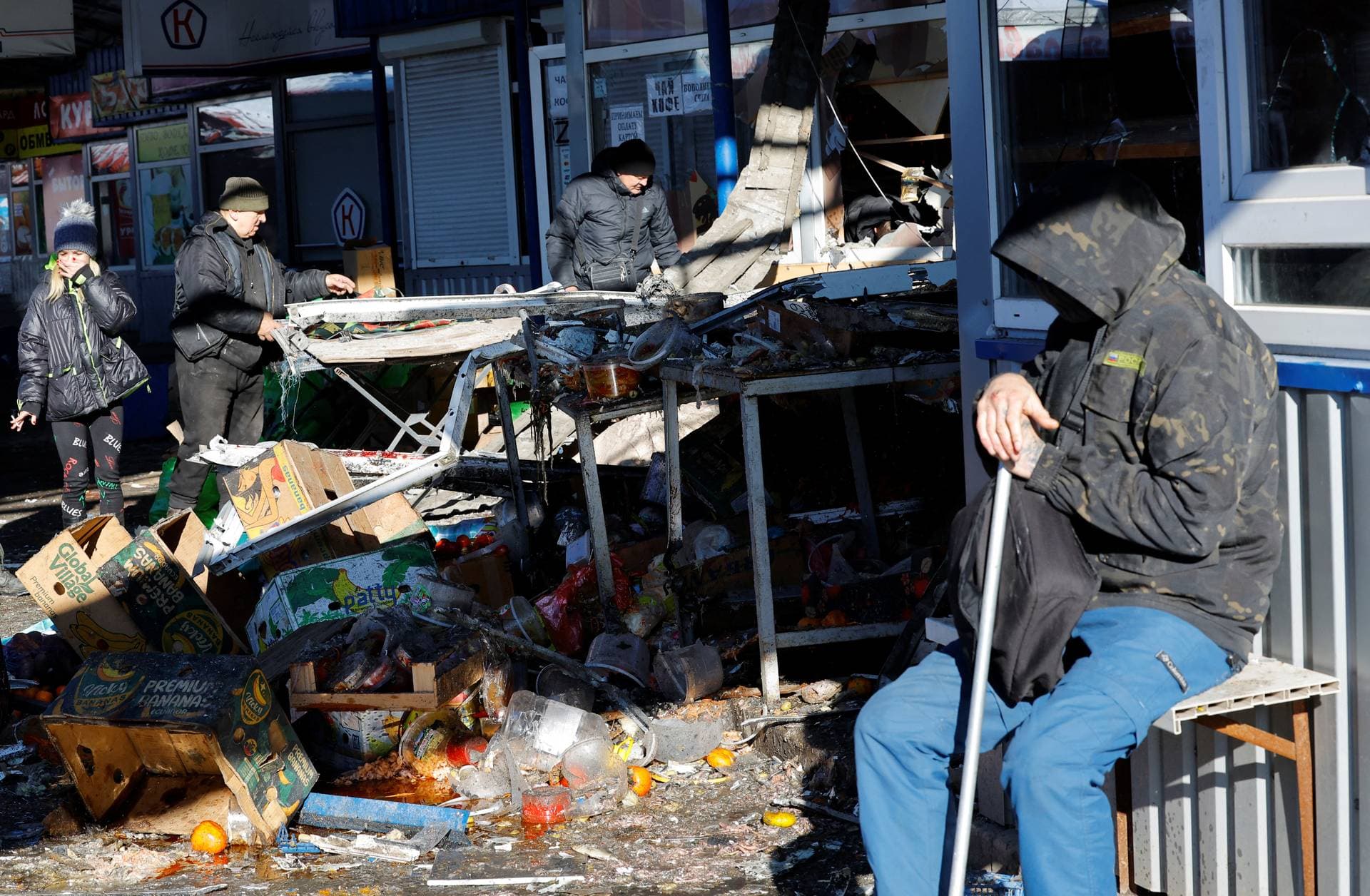 People remove debris at a food market on Sunday following what local Russian-installed authorities say was a Ukrainian military strike on Russian-controlled Donetsk