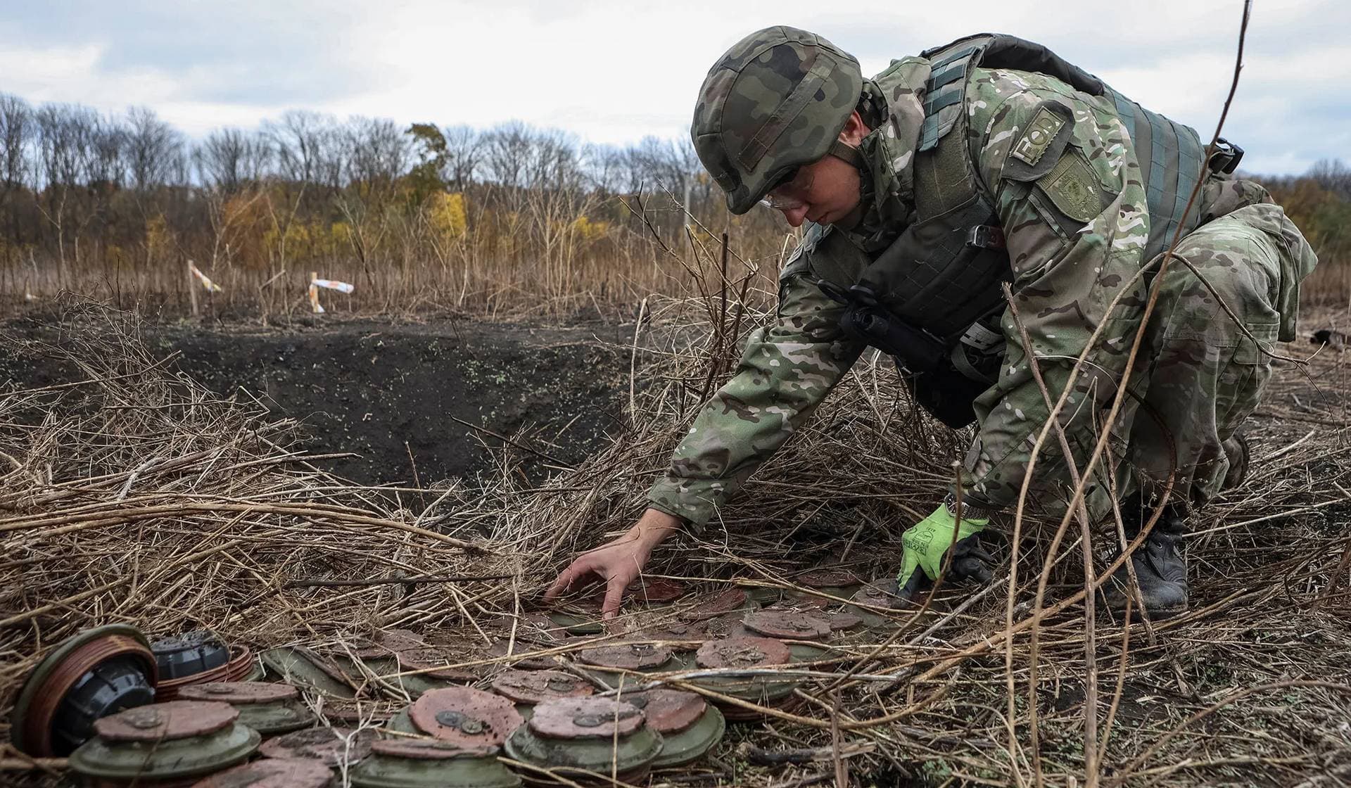 a member of the National police special de-mining unit works with mine fuses during a demining operation near Izum