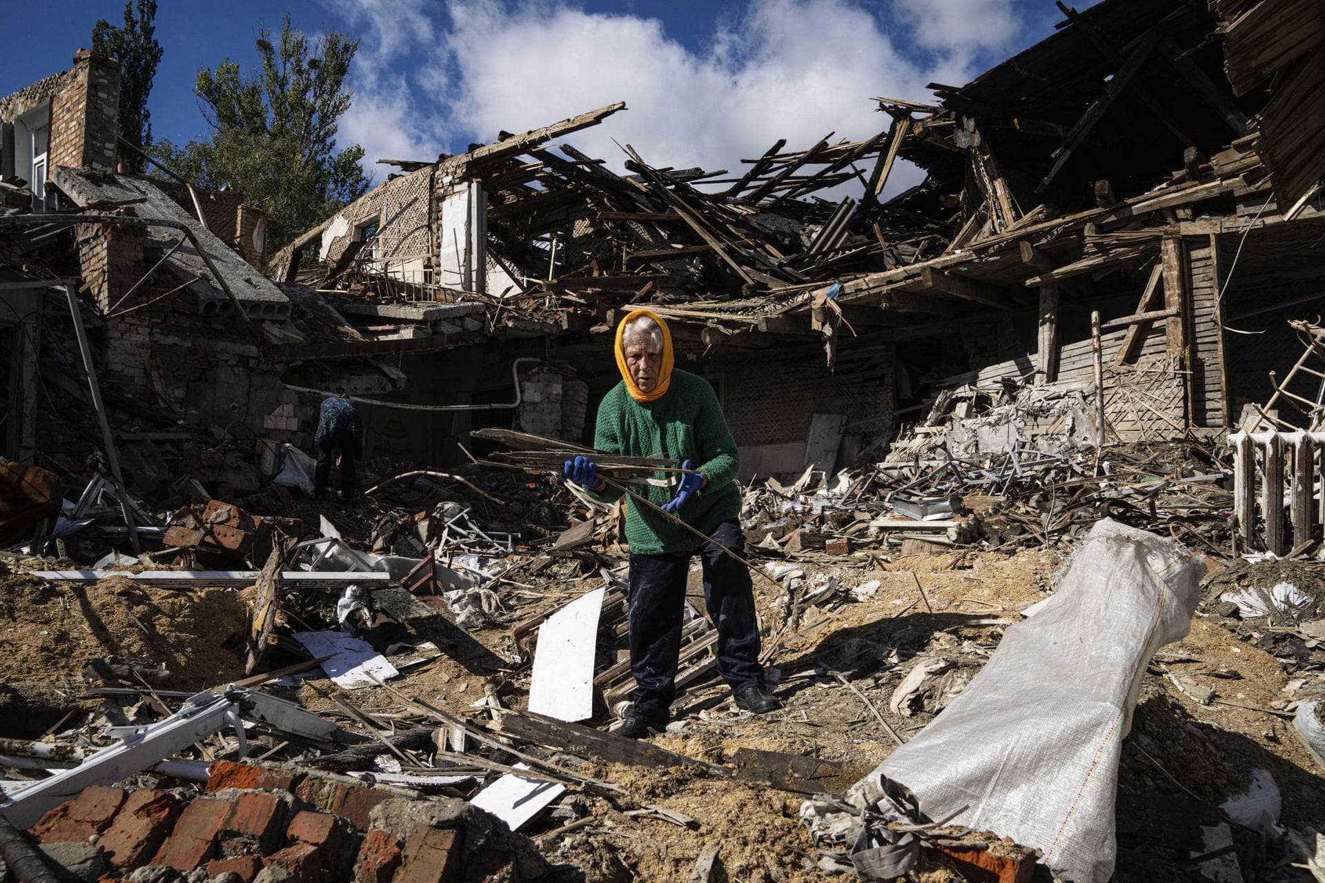 Tetyana collects a wood to heat for heating from a destroyed school where Russian forces were based in the recently retaken area of Izium