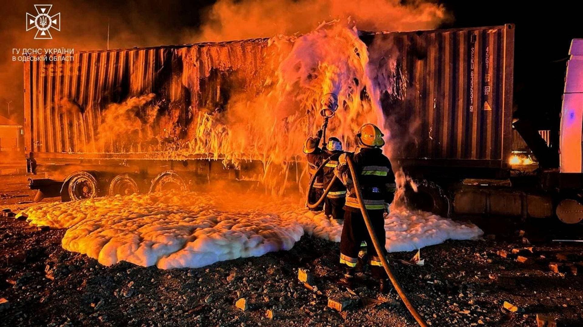 Firefighters work at a compound of a port on Danube river damaged by a Russian drone strike in Odesa region