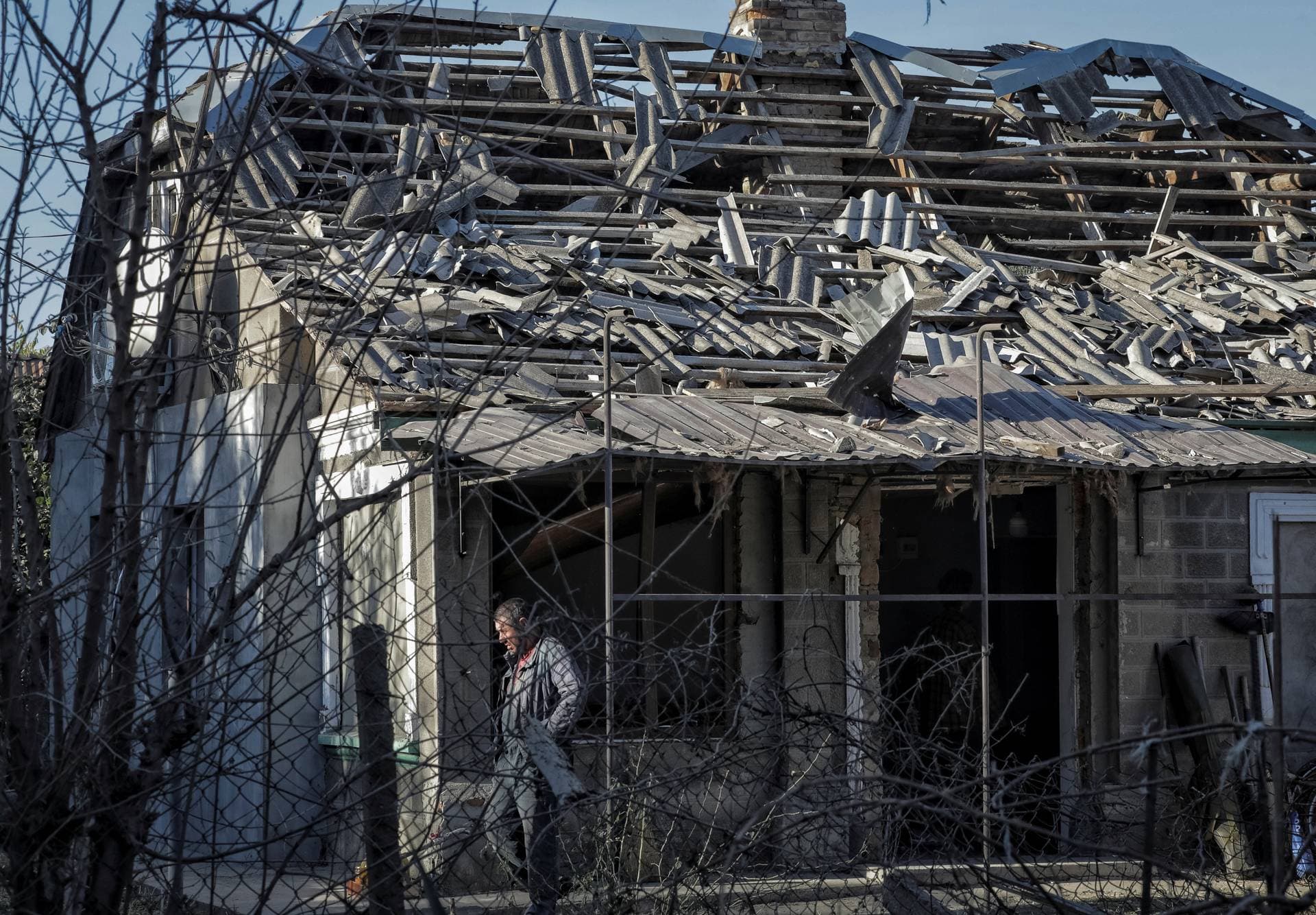 A local resident is seen outside a house damaged by a Russian drone strike in Izmail