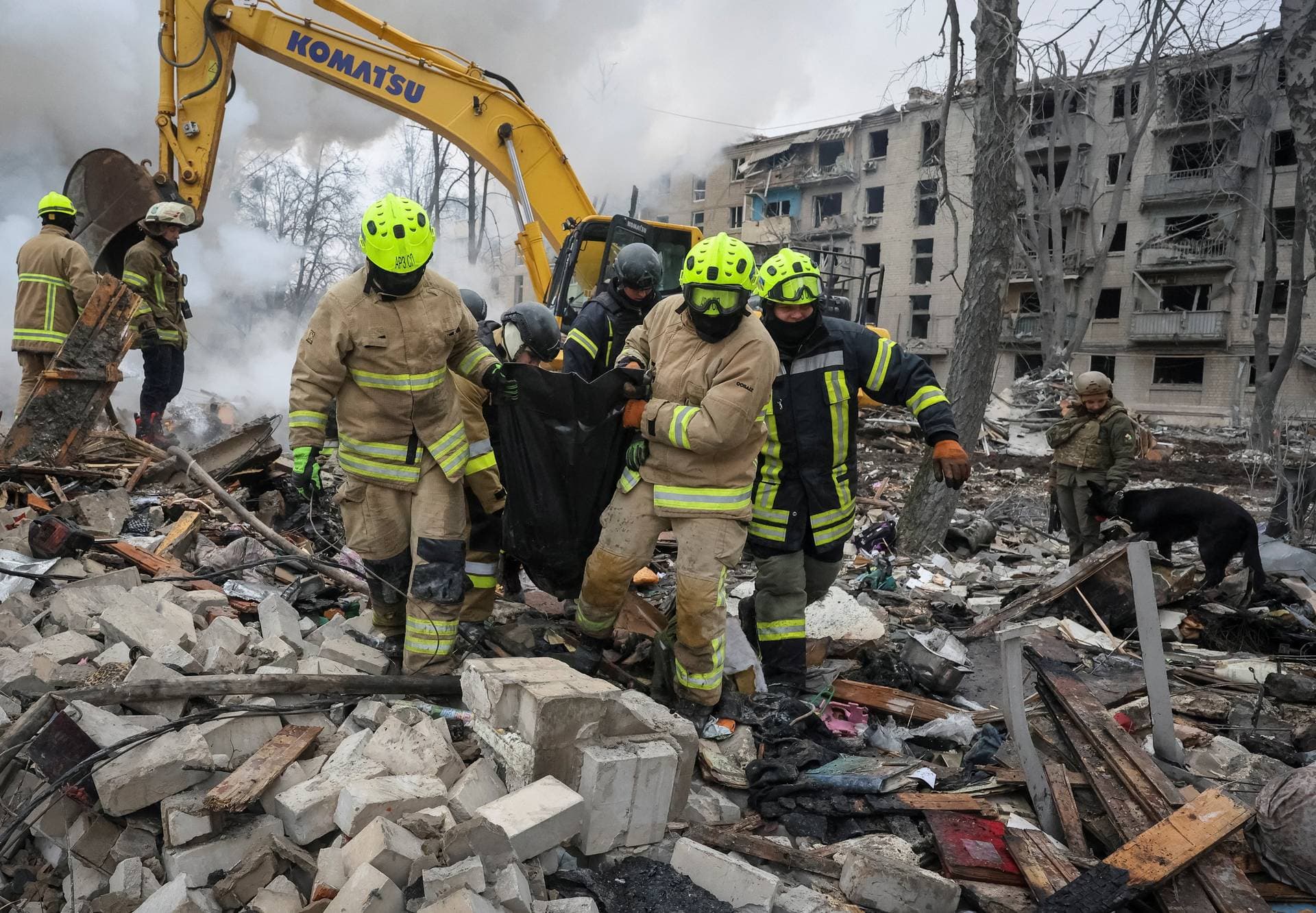 Rescuers carry a bag with the body of a person found under debris of an apartment building which was hit during overnight Russian missile strikes in Kharkiv
