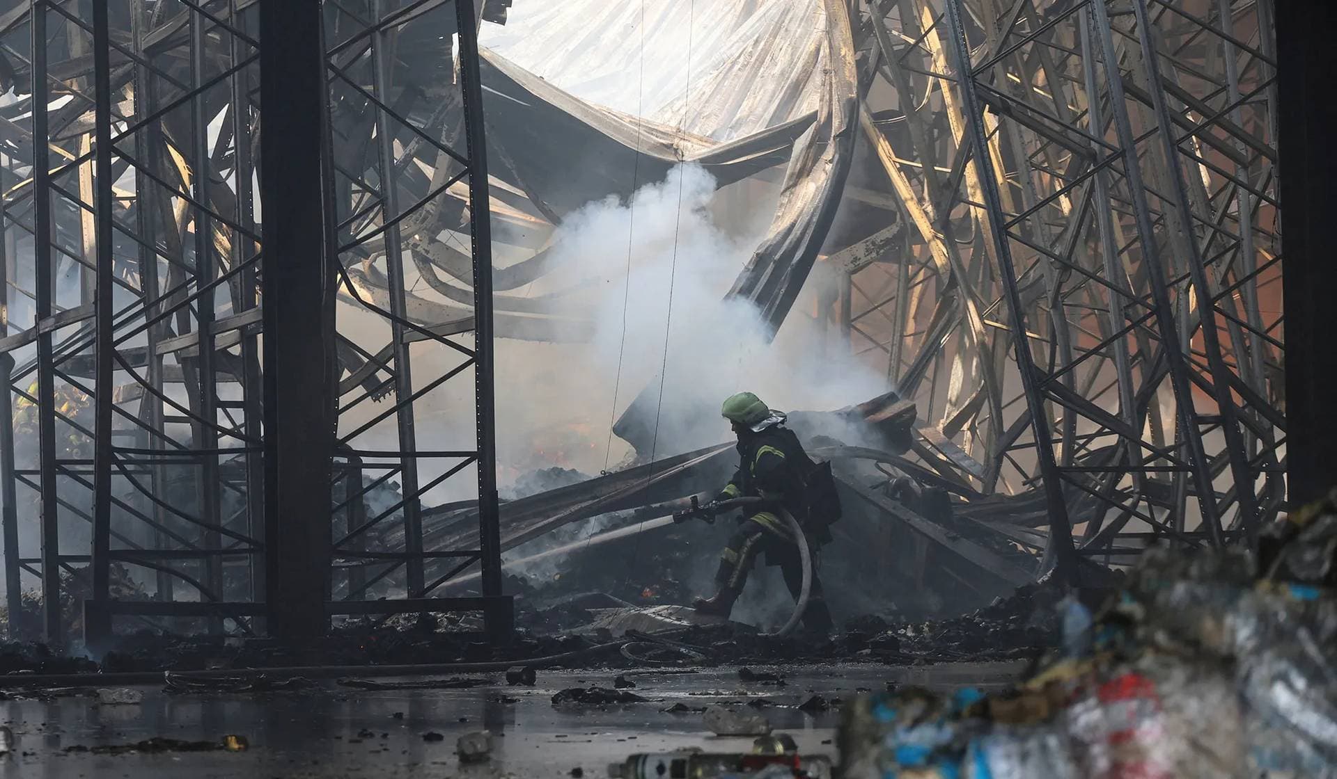A firefighter works inside a food warehouse hit by a Russian military strike in the village of Vasyshcheve outside Kharkiv