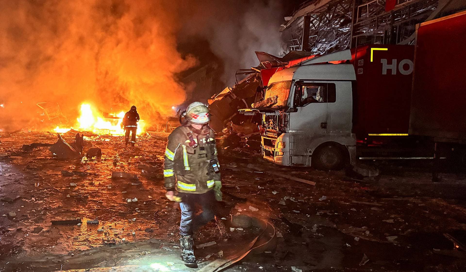 Firefighters work at the site of a logistics hub of a private delivery company hit by Russian missile strikes in Kharkiv