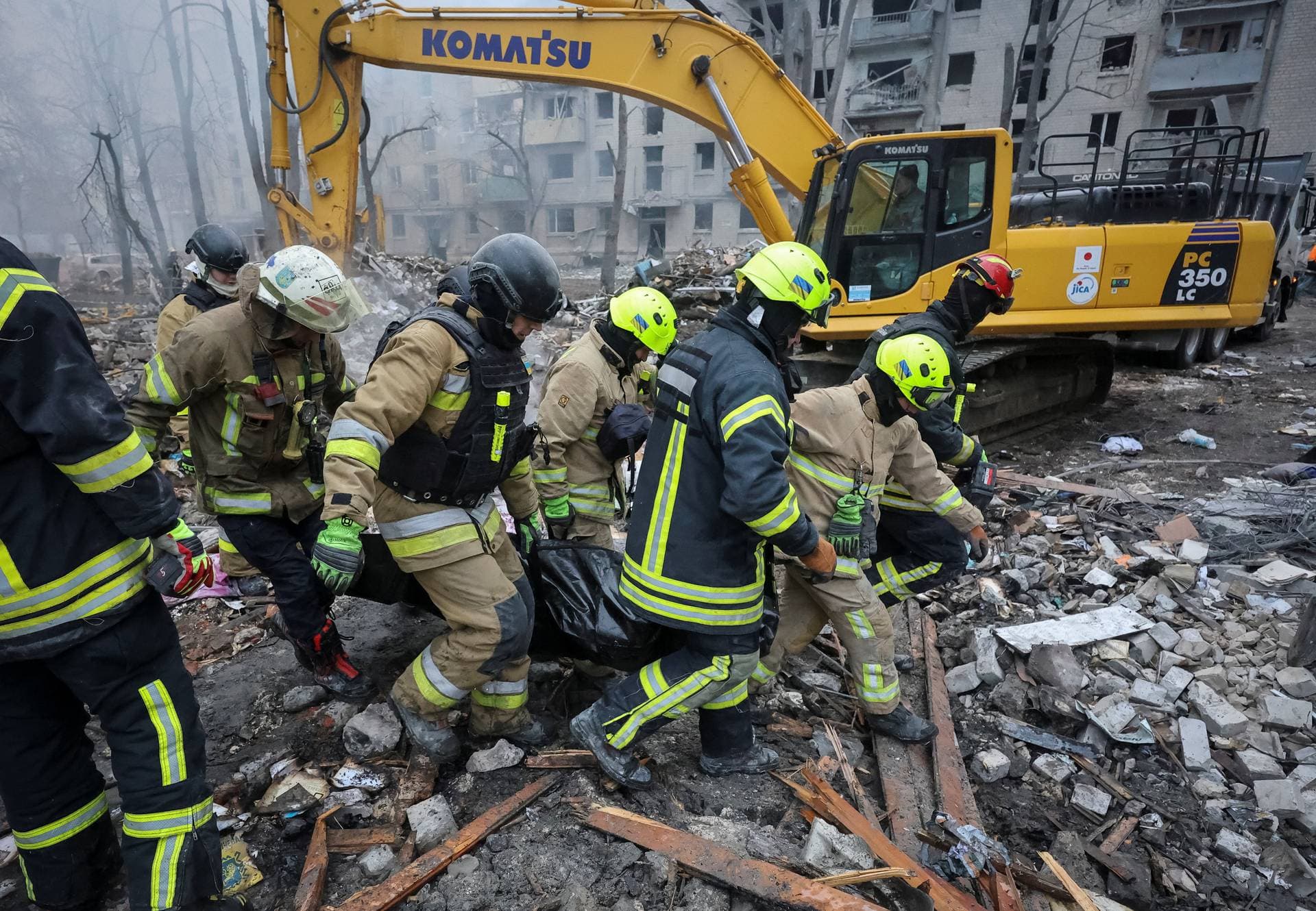 Rescuers carry a bag with the body of a person found under debris of an apartment building which was hit during overnight Russian missile strikes in Kharkiv