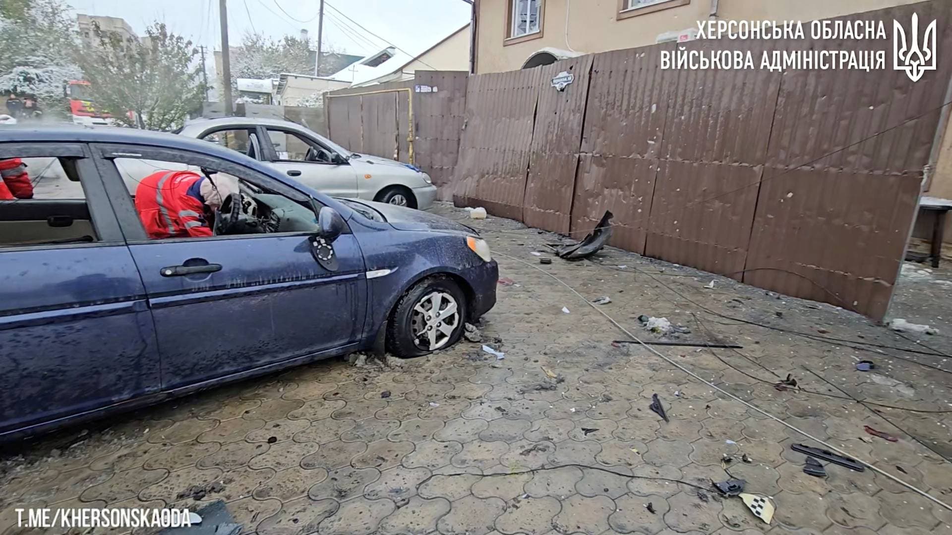 First responders work near a damaged car whose occupant was killed after a reported Russian artillery strike in Kherson