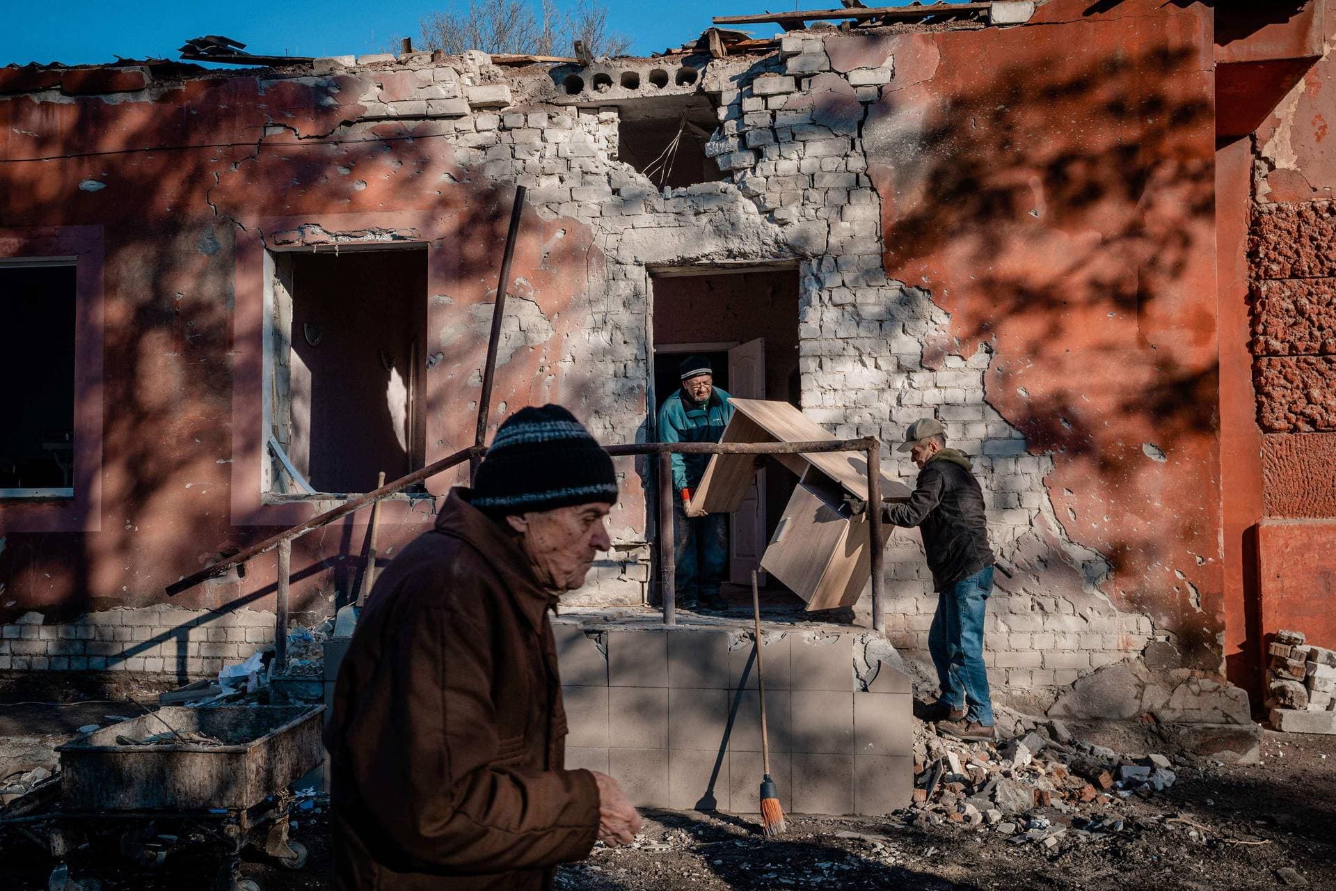Workers carry furniture from a hospital maternity unit damaged after a Russian shelling in Kherson