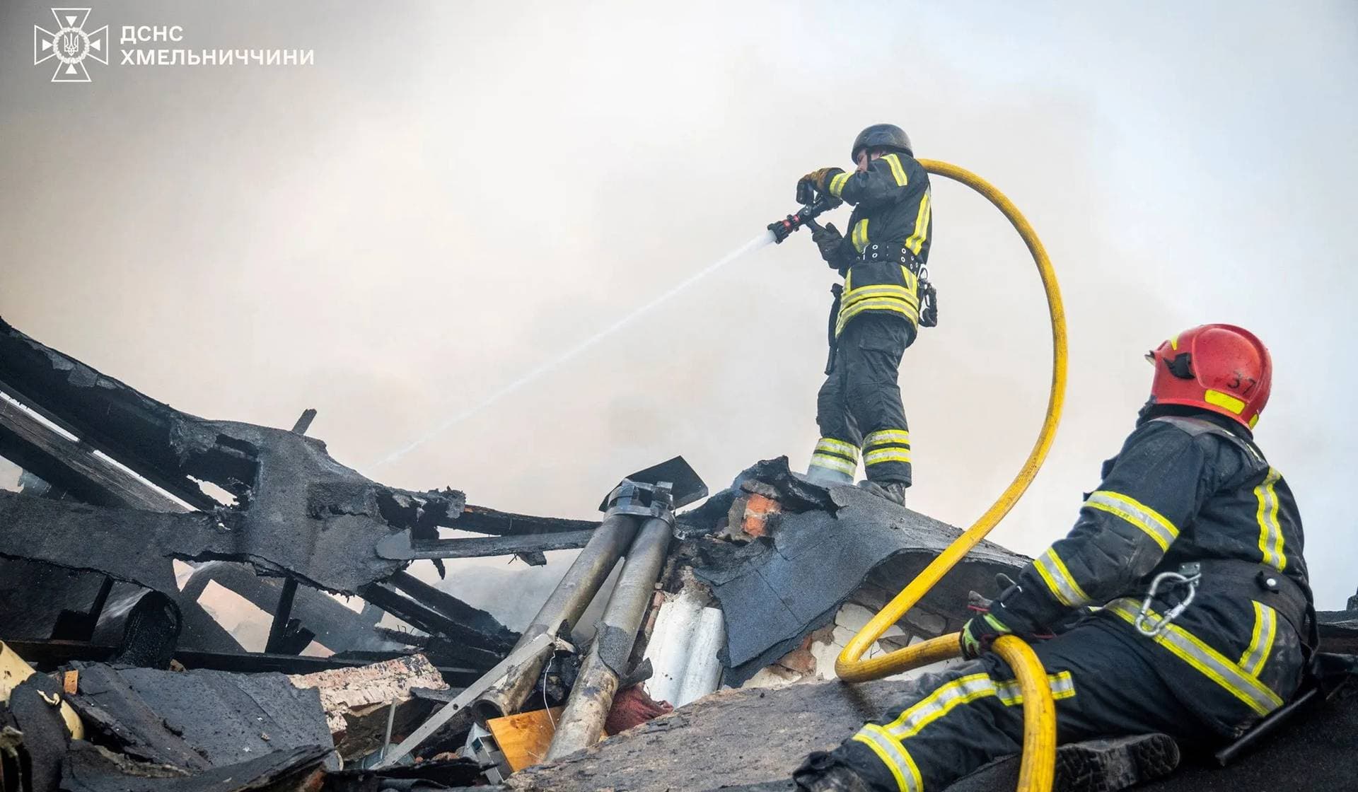 Firefighters work at the site of destroyed garages of an automotive enterprise hit during Russian drone and missile strikes in Khmelnytskyi