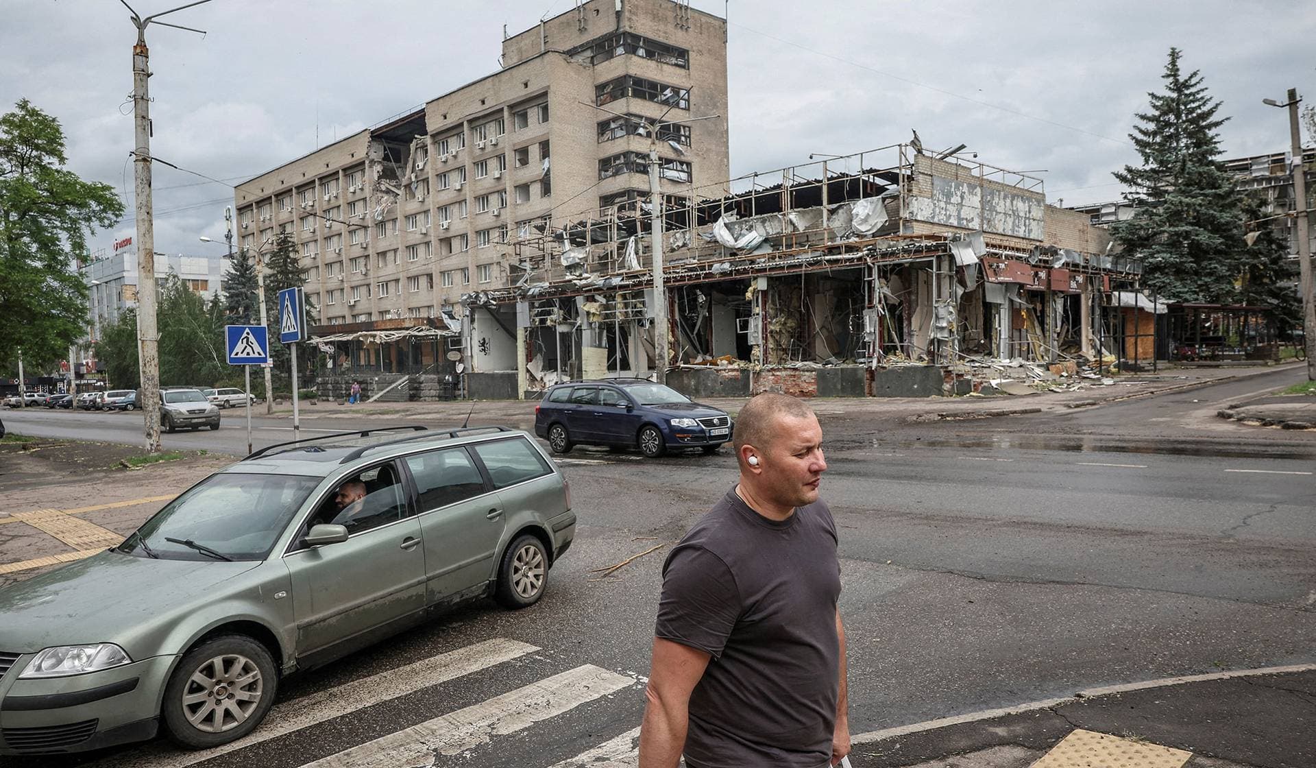 A man walks near a damaged building in the frontline city of Kramatorsk