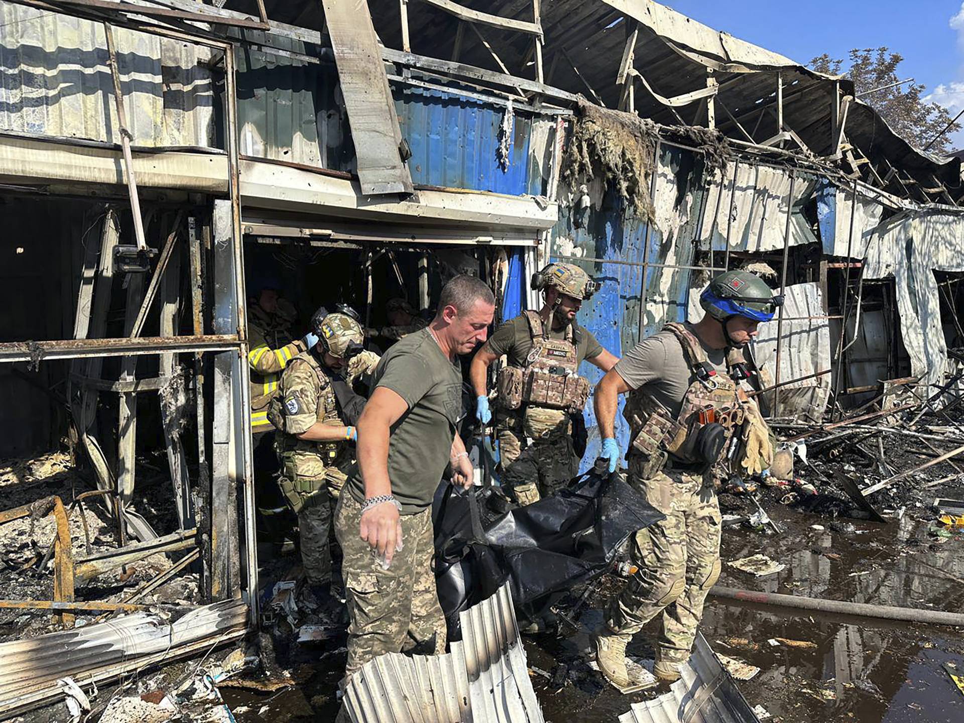 Rescue workers carry the body of one of the at least 16 victims out of the market in Kostiantynivka