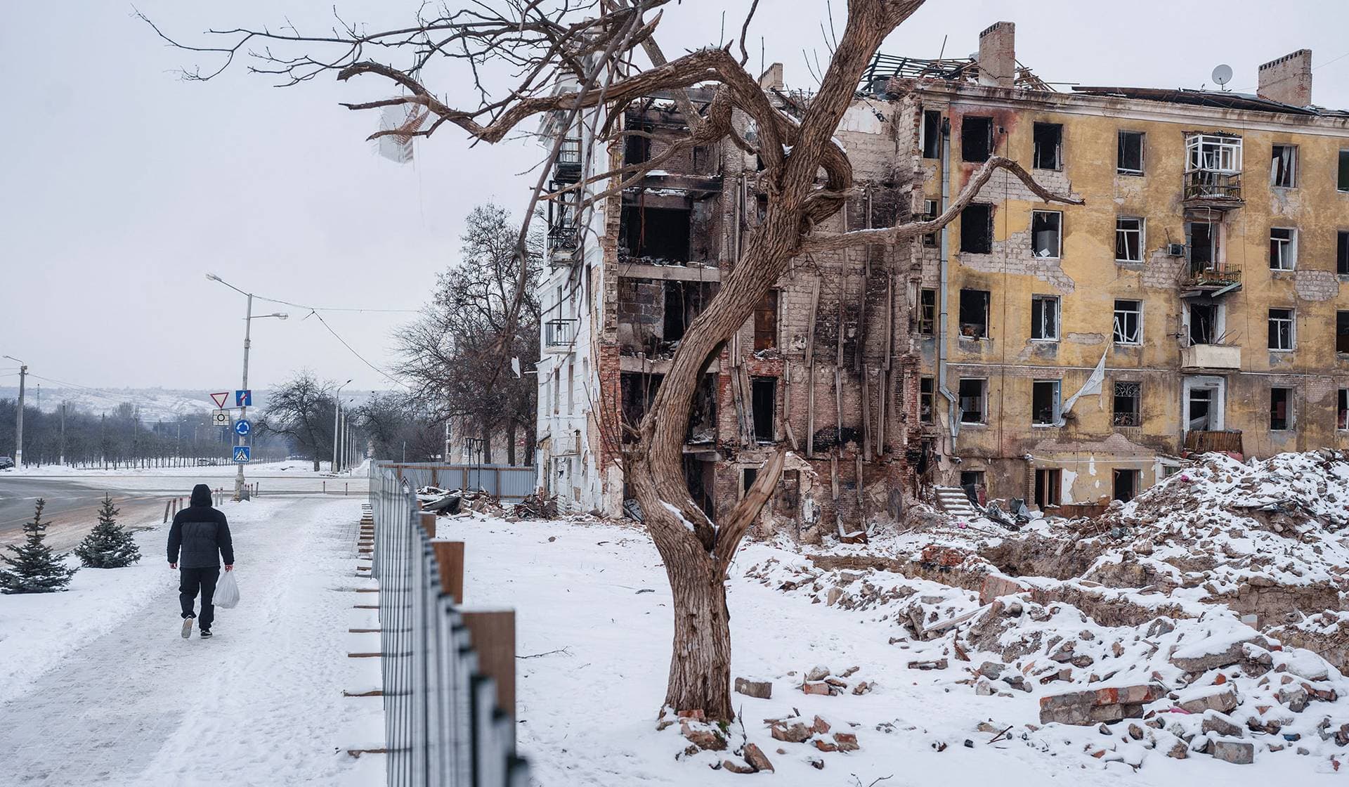 A resident walks next to an apartment building hit by a Russian military strike in Kramatorsk
