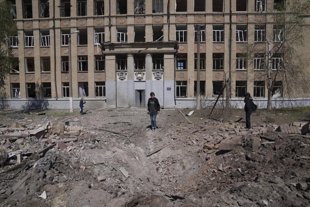 A woman looks on a crater of an explosion after Russian airstrike in Kostyantynivka