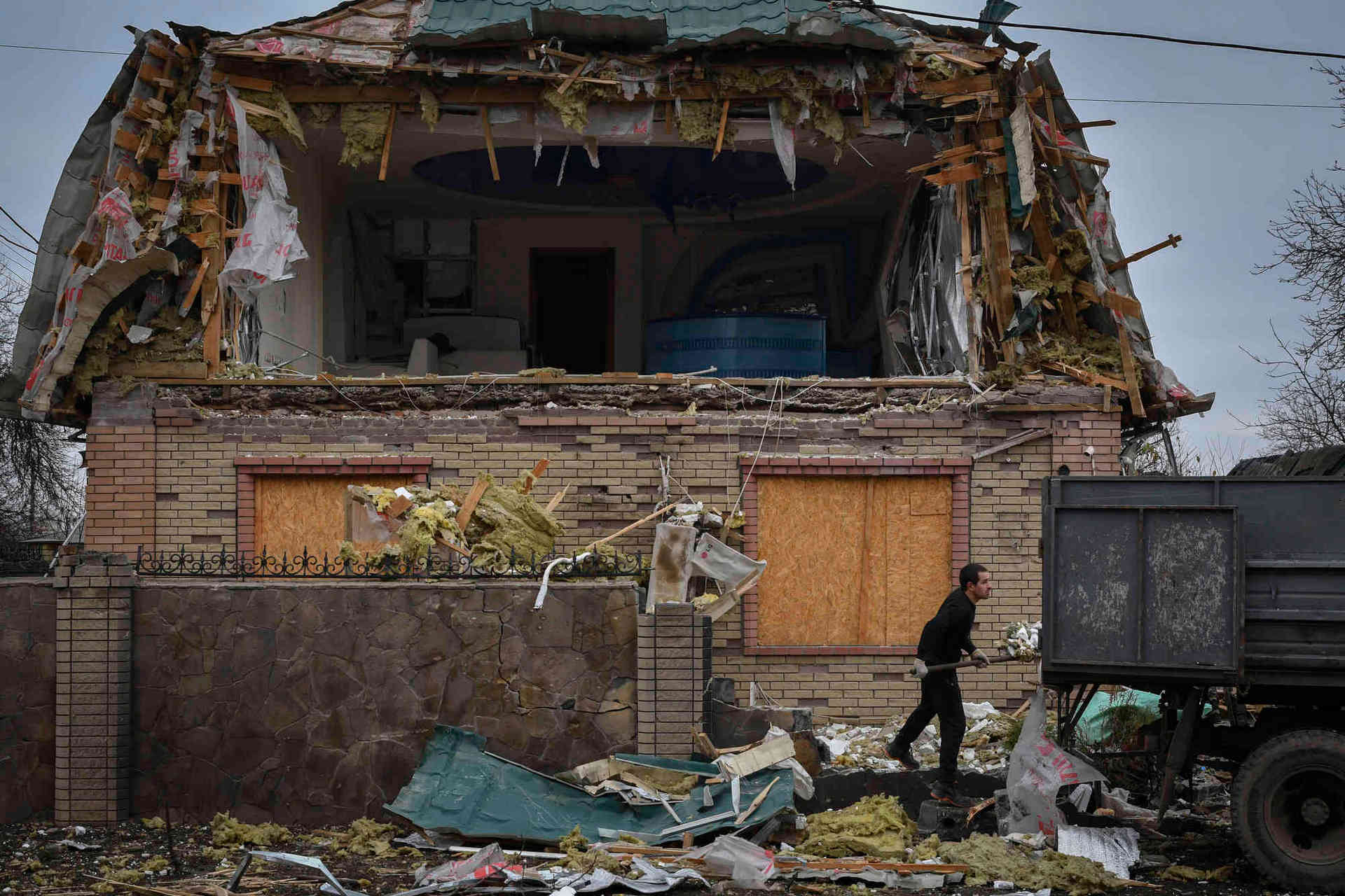 A local resident works to clean the debris from damaged house after Russian shelling in Kramatorsk