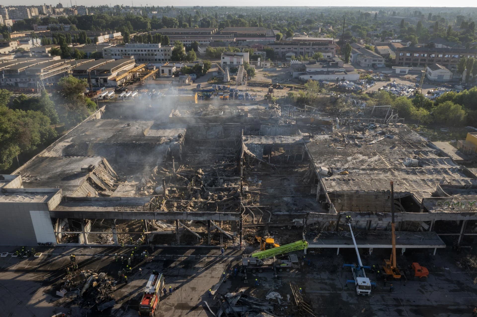 Ukrainian State Emergency Service firefighters work to take away debris at a shopping center burned after a rocket attack in Kremenchuk