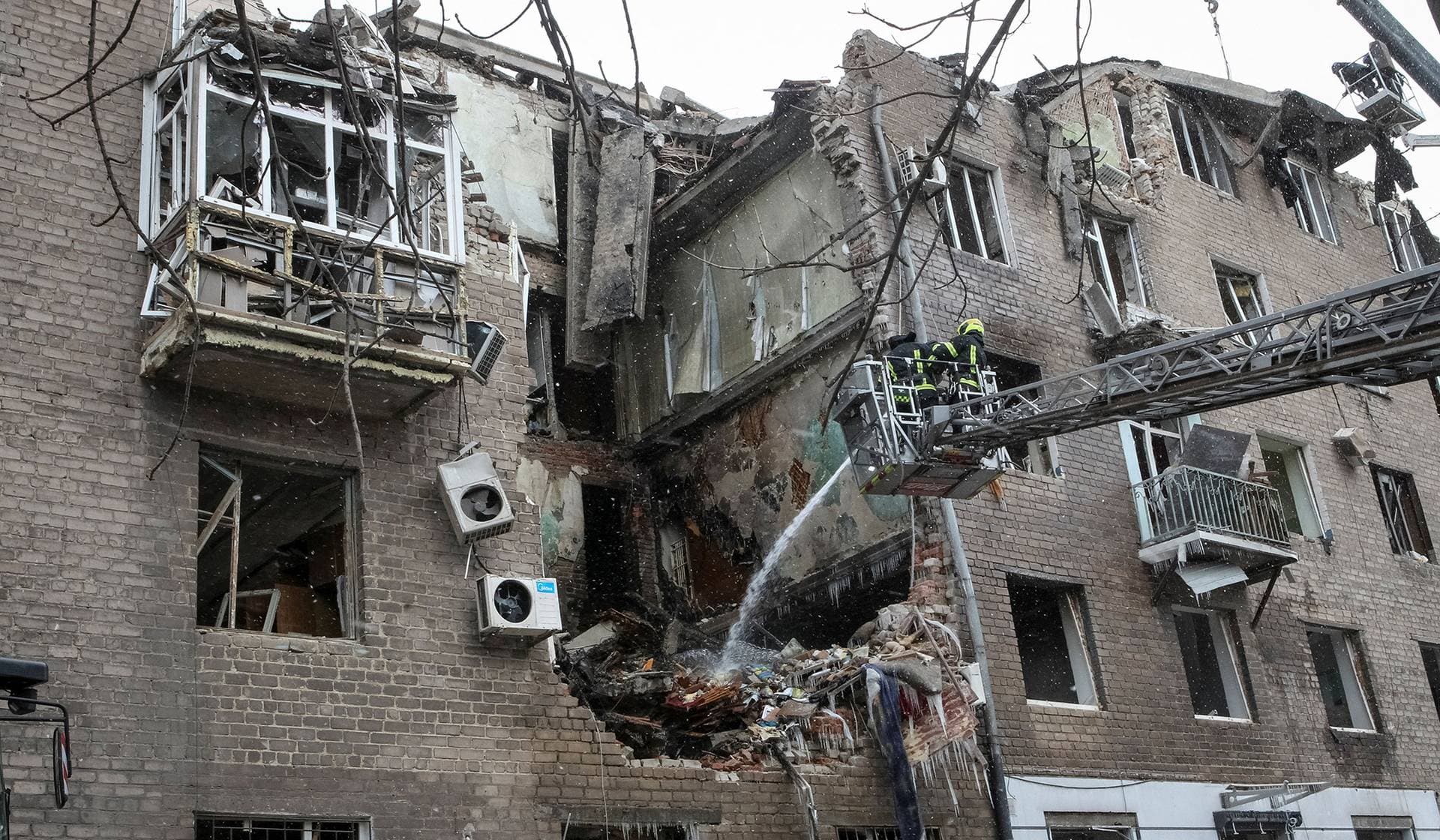Firefighters work at the site of the apartment building hit by a Russian missile strike in the city of in Kryvyi Rih