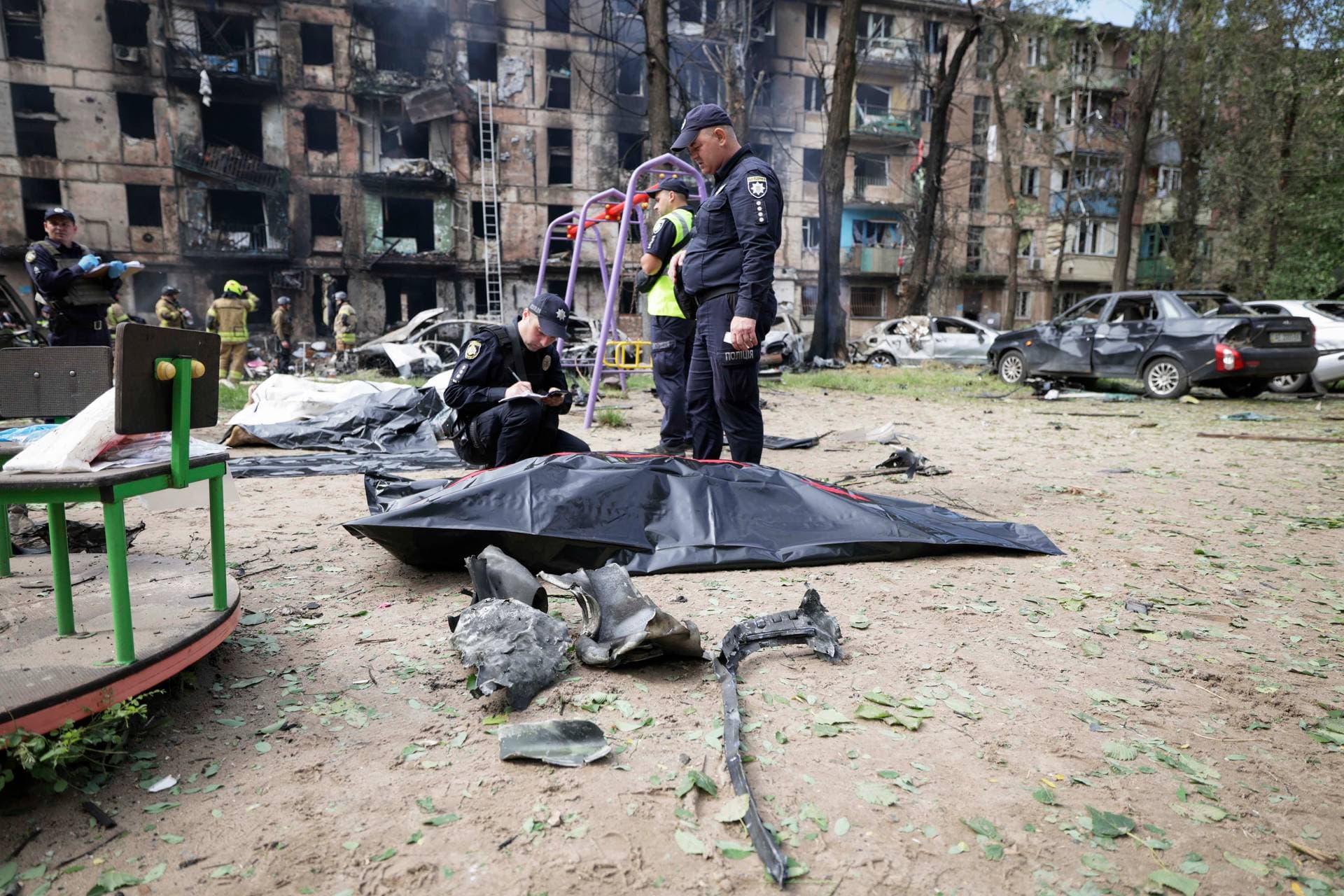 Police inspect a dead body at the scene of damaged multi-storey apartment building caused by the latest rocket Russian attack in Kryvyi Rih