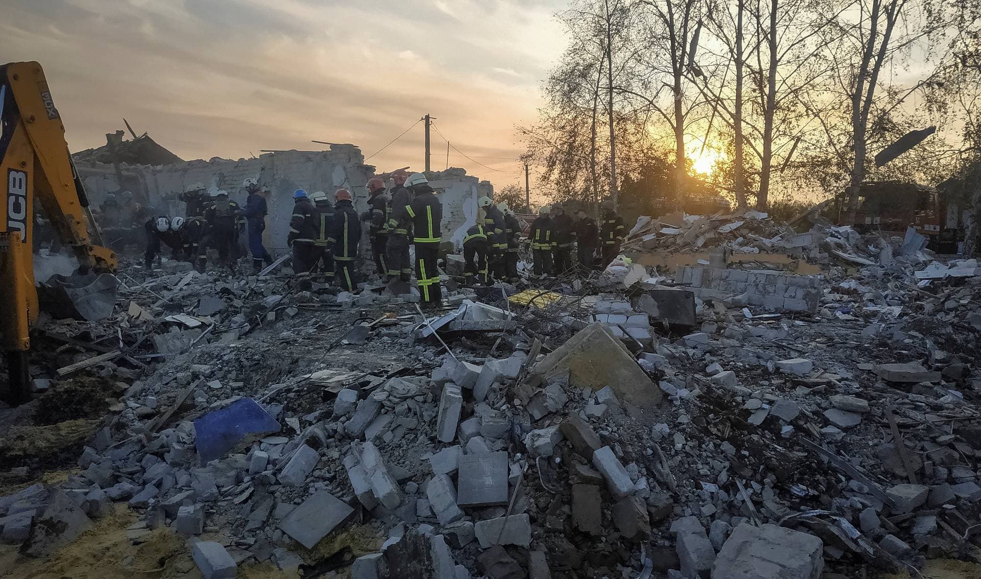 Rescues work at a site of a Russian military strike in the village of Hroza