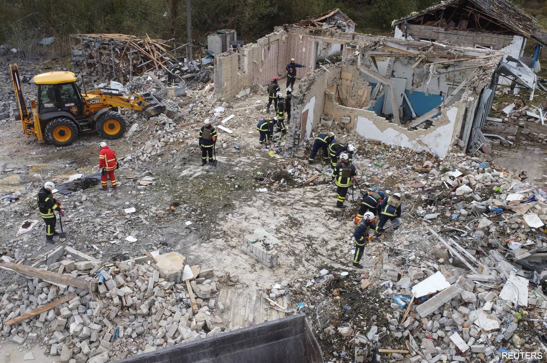 Rescues remove debris at a site of buildings of a local cafe and a grocery store in the village of Hroza