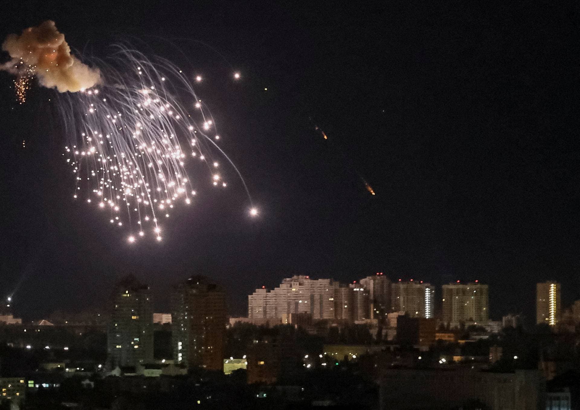 An explosion of a drone is seen in the sky over the city during a Russian drone strike in Kyiv