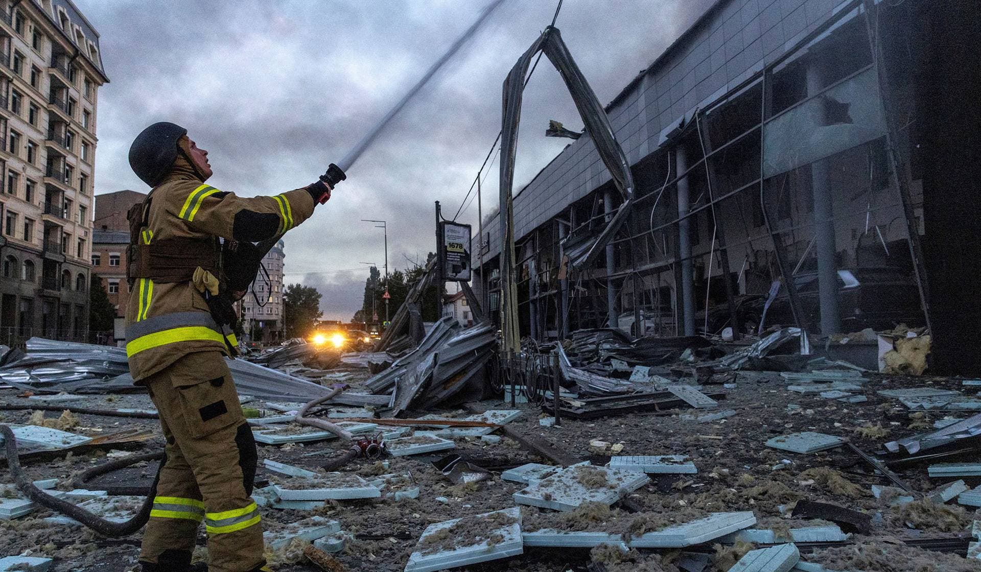 An emergency worker responds to a fire in a car dealership that was struck during overnight Russian missile and drone attacks in Kyiv