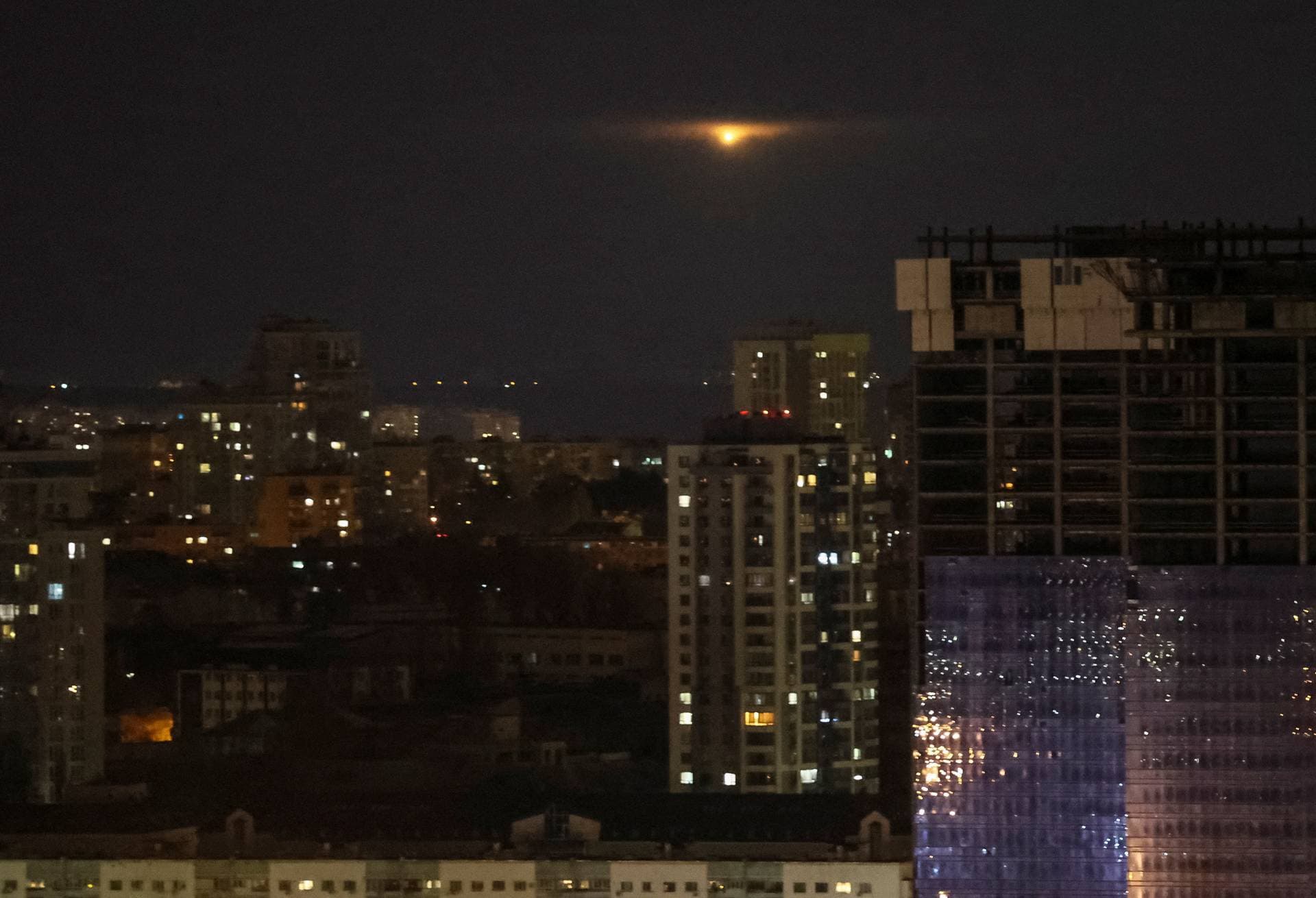 An explosion of a drone is seen in the sky over the city during a Russian drone strike in Kyiv