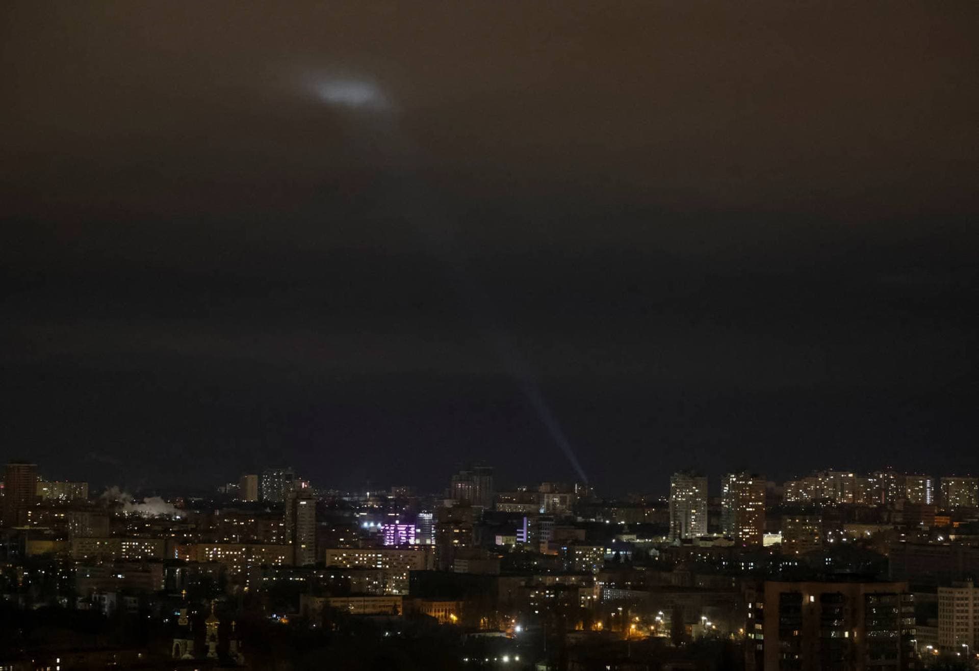 Ukrainian servicemen use a searchlight as they search for drones in the sky over the city during a Russian drone strike in Kyiv
