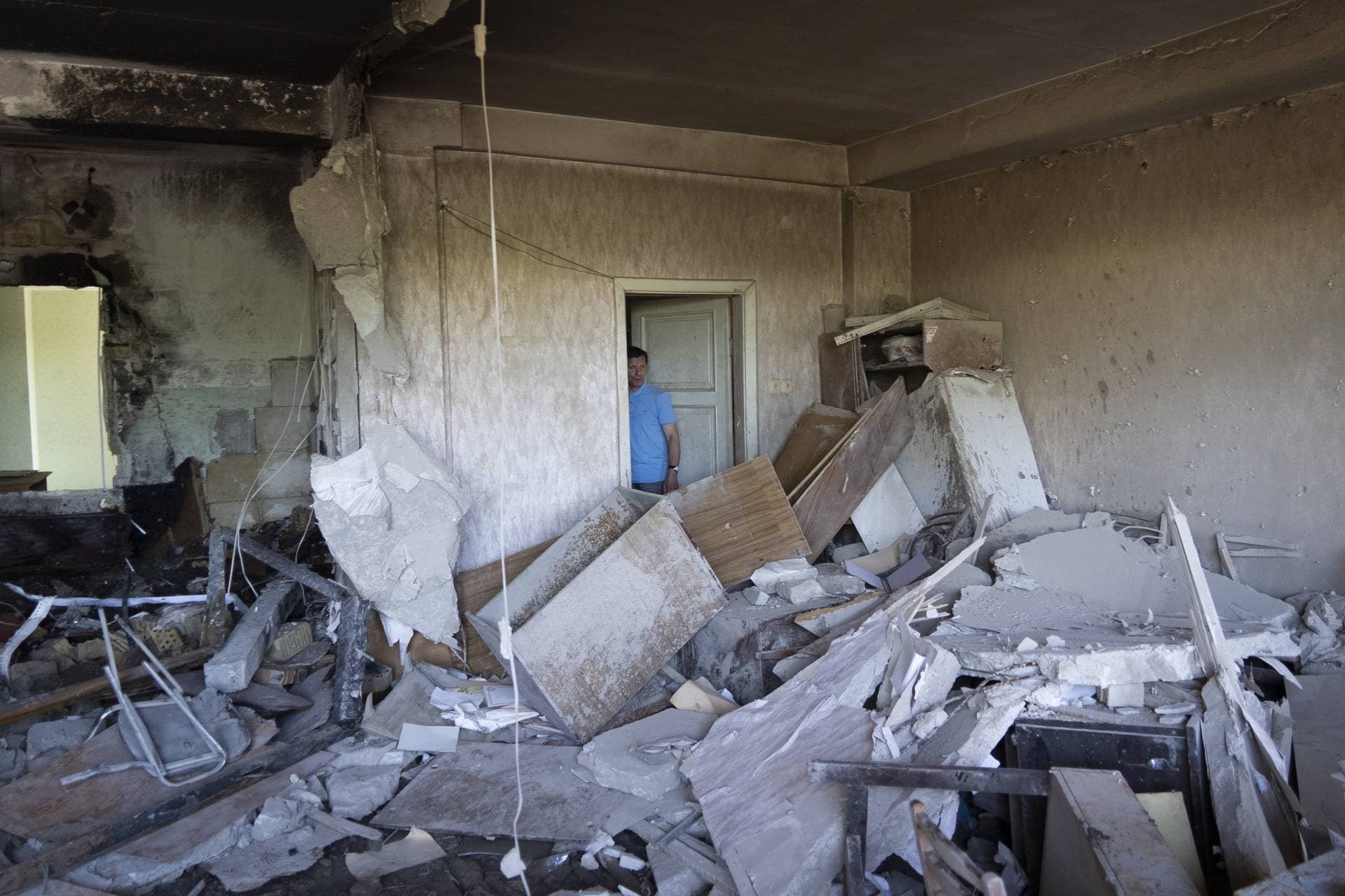 Vladimir Golubenko looks at his office damaged by a drone during a night attack, in Kyiv