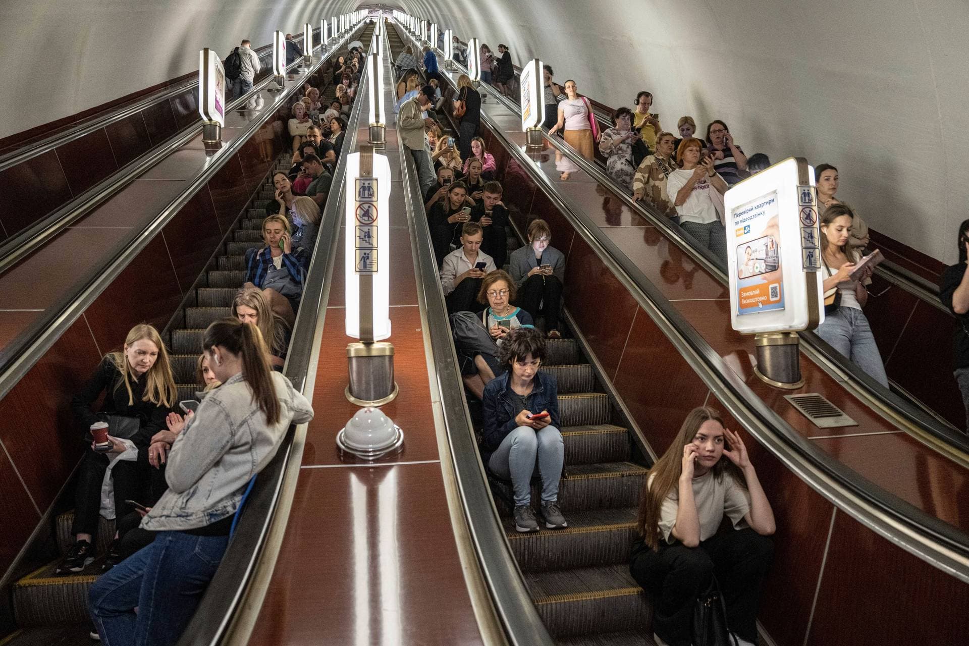 People take cover at a metro station during a Russian rocket attack in Kyiv