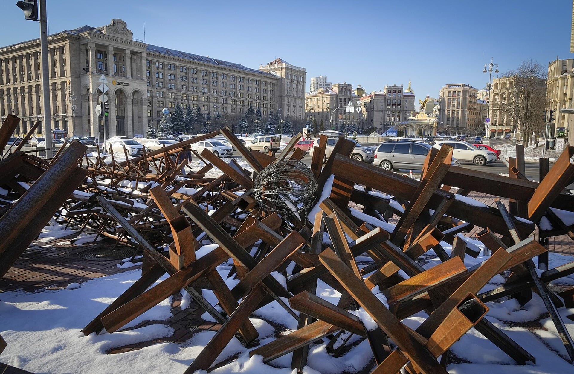 Cars ride past anti-tanks hedgehogs in the main square in Kyiv