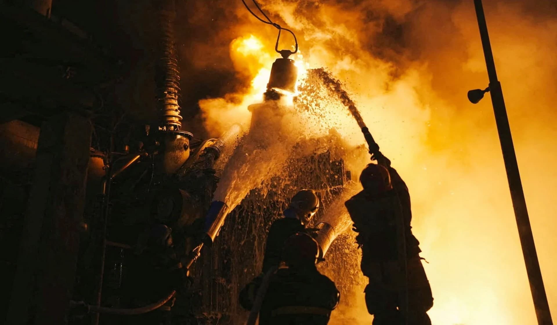 Firefighters work at a site of critical power infrastructure hit during Russia's drones attacks in Kyiv