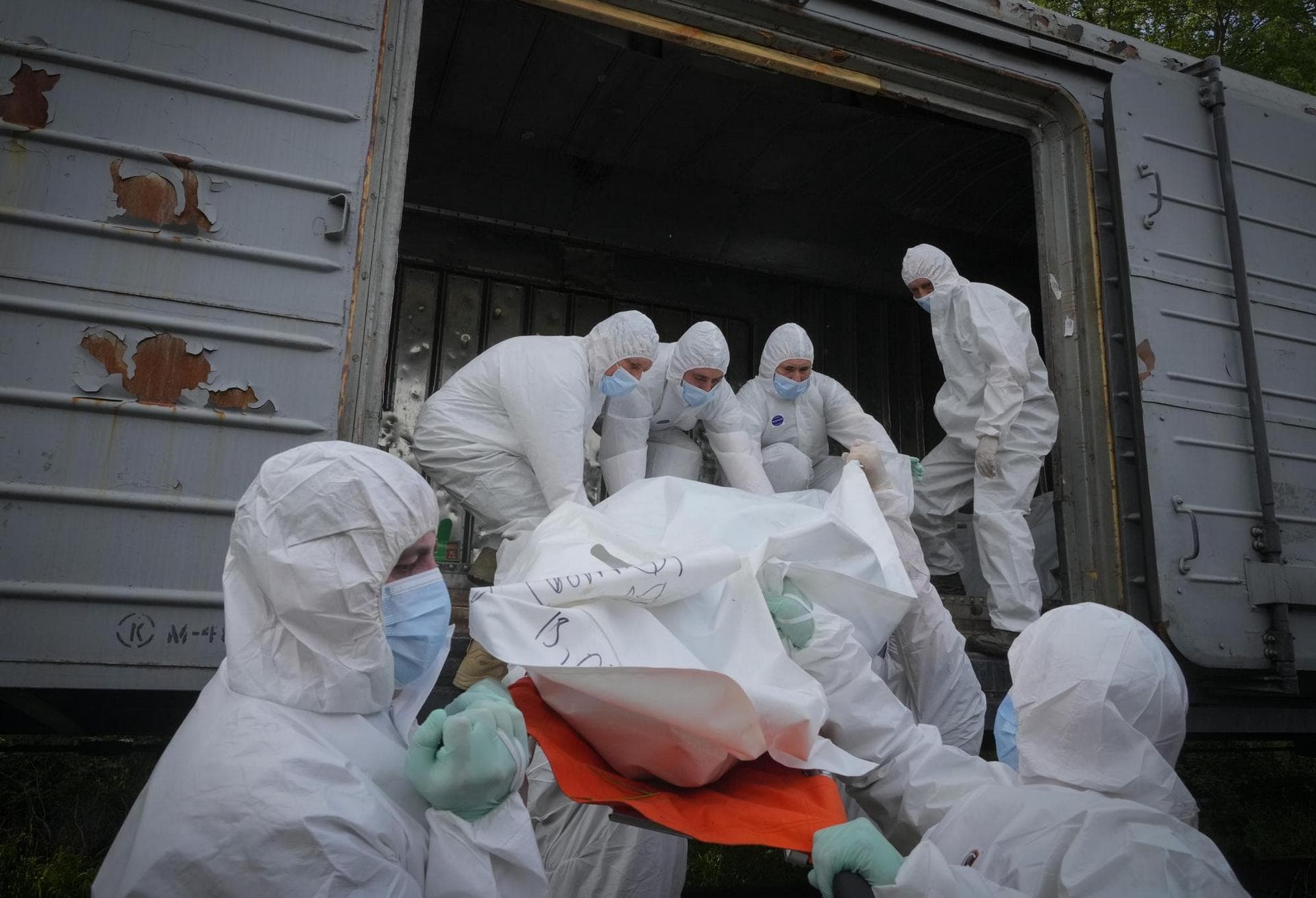 Ukrainian servicemen load bodies of Russian soldiers into a railway refrigerator carriage in Kyiv