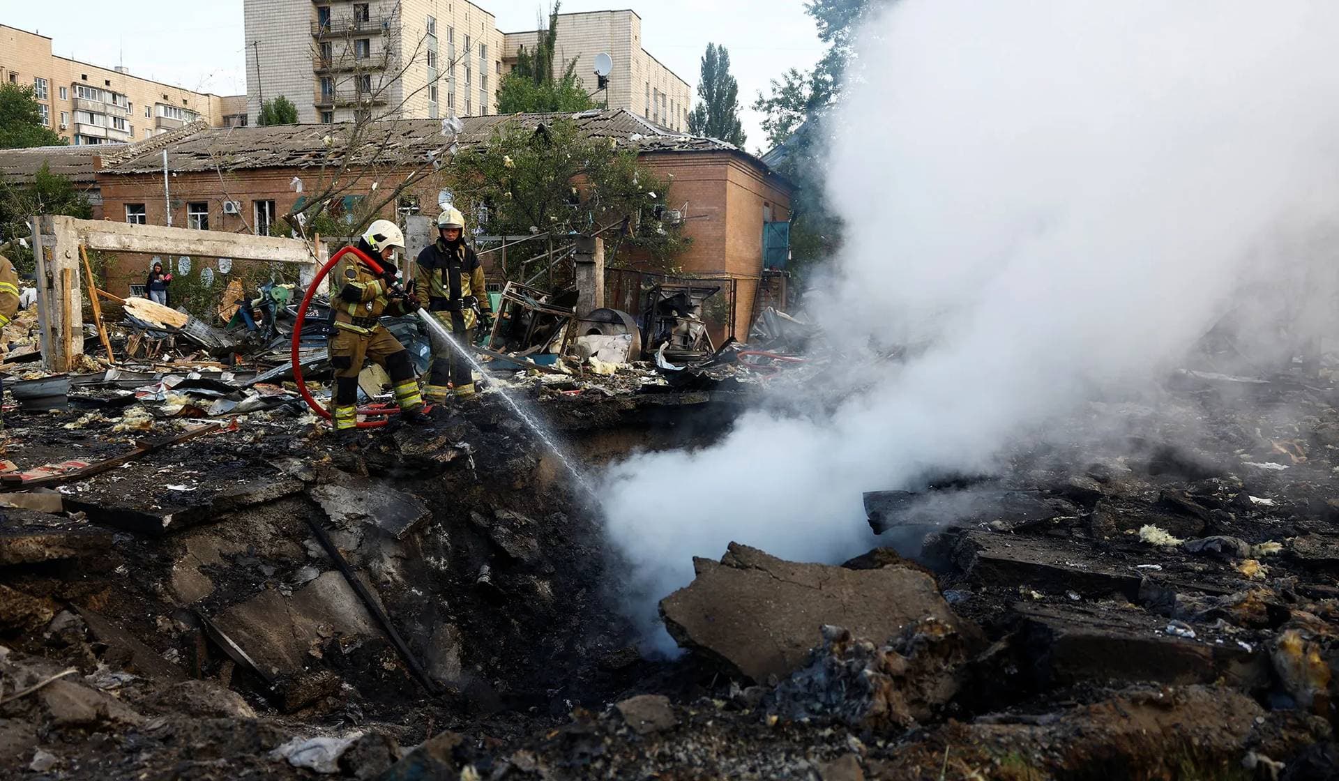 Firefighters work at a site in a residential area damaged during a Russian missile strike in Kyiv